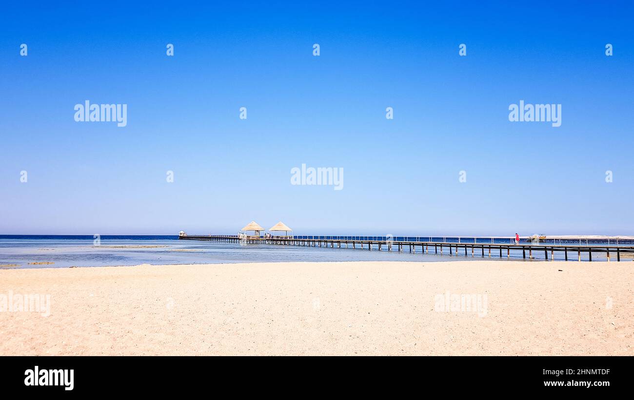 Una bellissima spiaggia di sabbia senza persone e un mare tropicale blu con sfondo blu cielo. Foto Stock