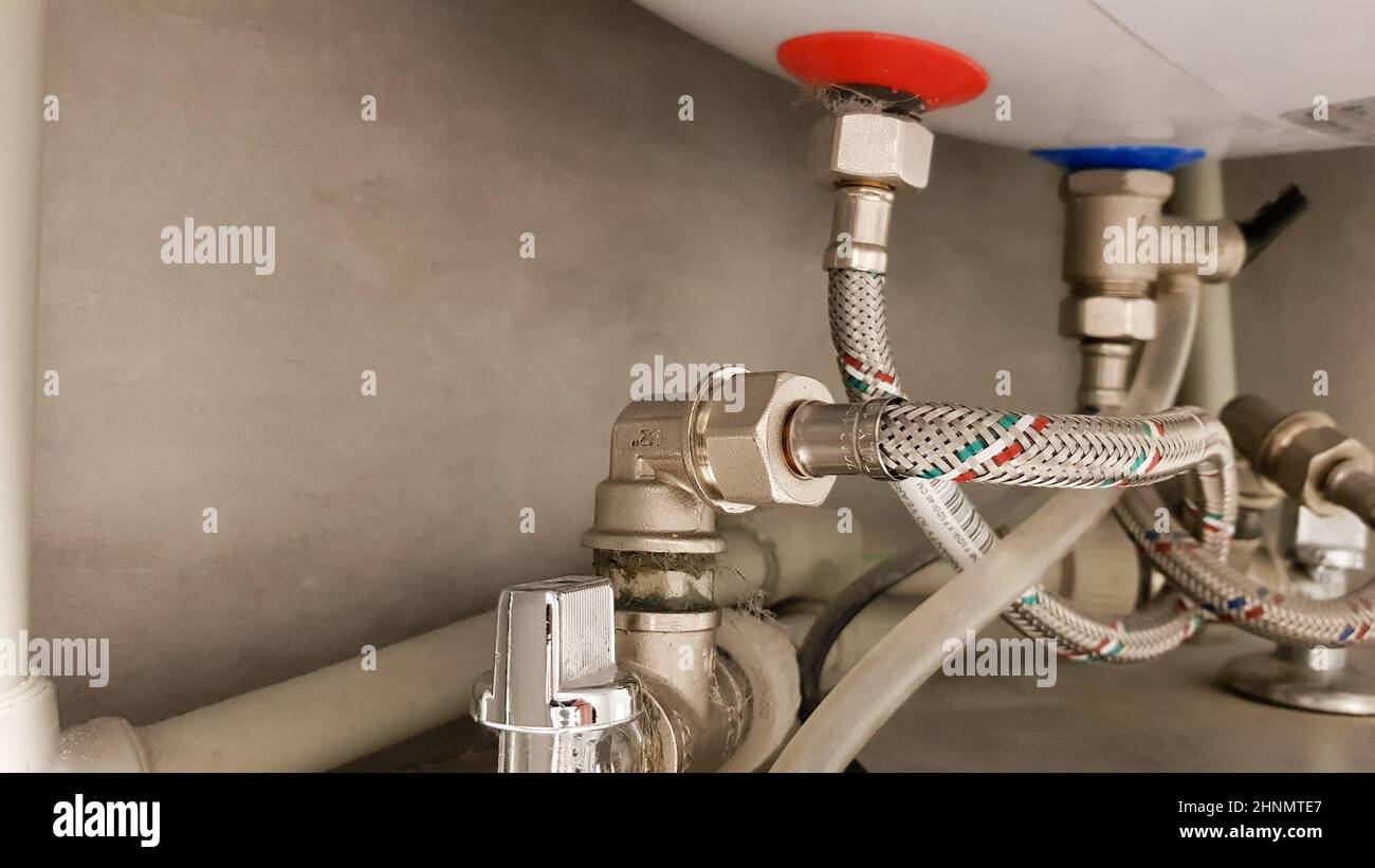 Collegamento dell'alimentazione idrica, dell'acqua calda e fredda alla  caldaia. Tubo per acqua calda e fredda in bagno. Collegamenti idraulici per  scaldabagno elettrico domestico Foto stock - Alamy