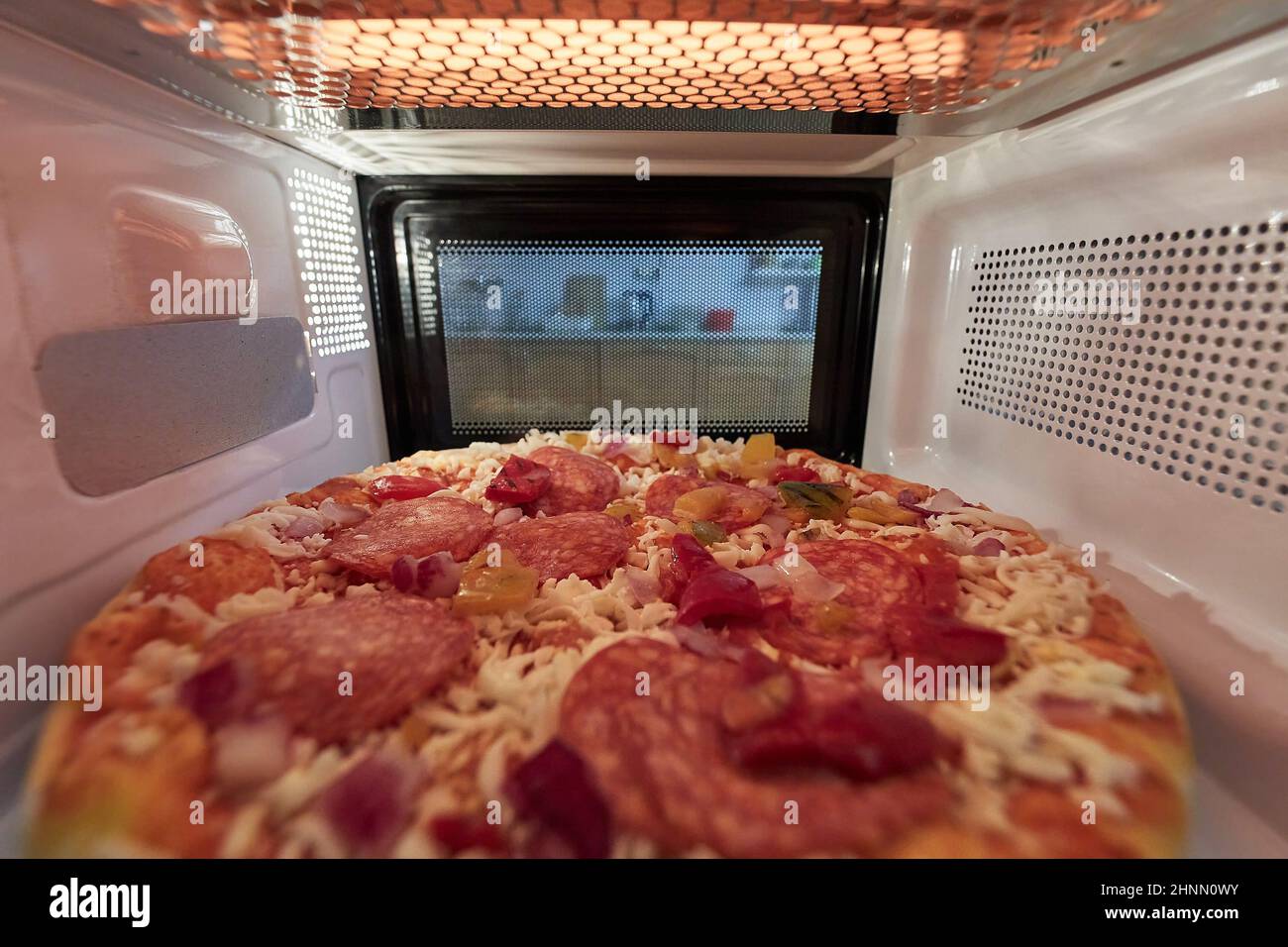 Riscaldamento pizza surgelata in un forno a microonde visto dall'interno  del retro Foto stock - Alamy