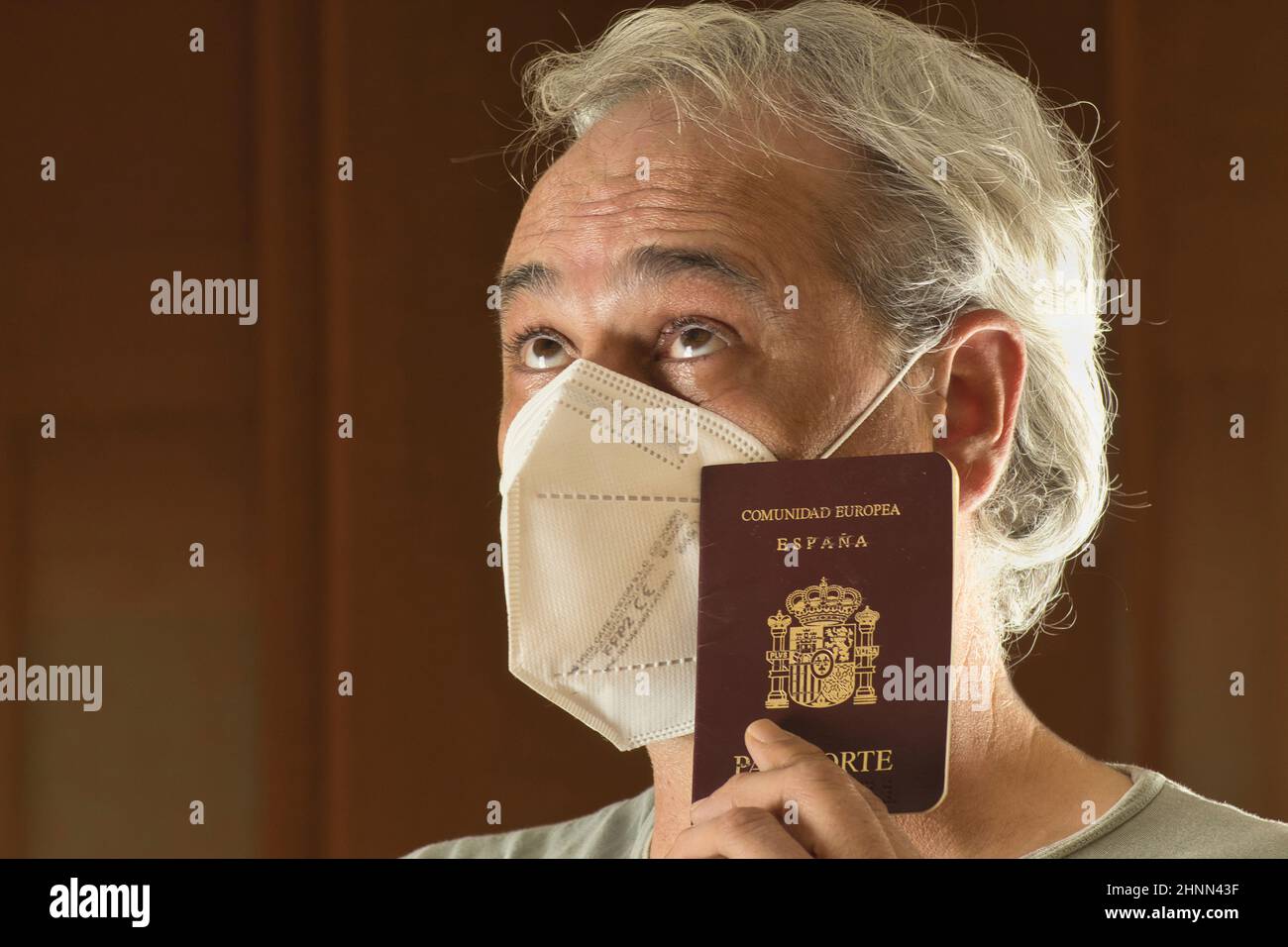 uomo maturo con maschera che pensa con un passaporto Foto Stock