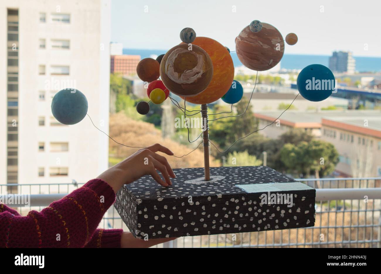 ragazza che tiene un incarico scolastico di un modello di un sistema solare Foto Stock