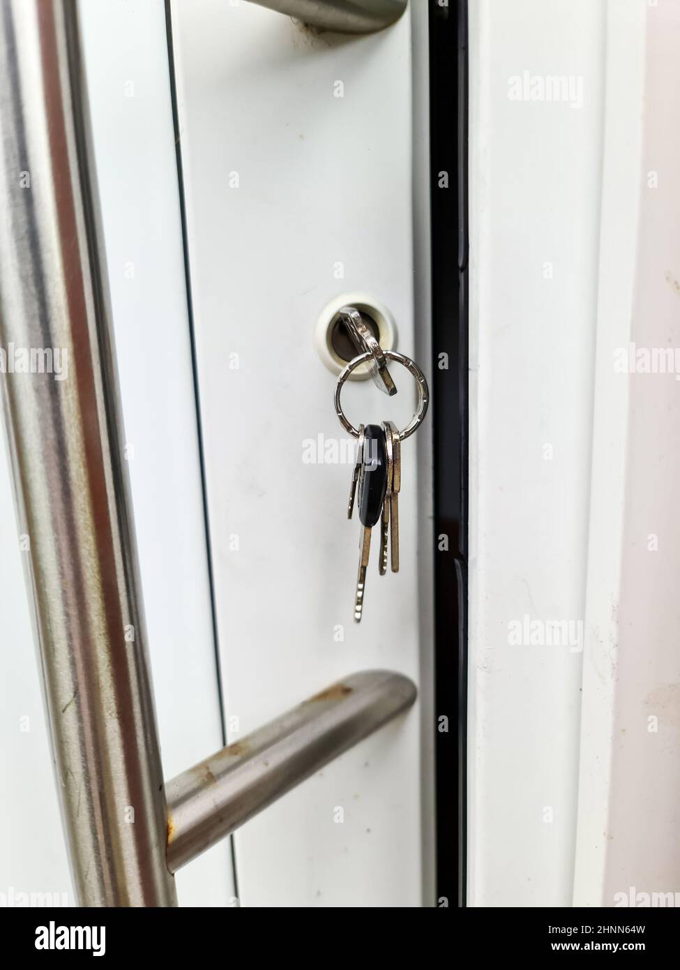 Aprire la porta dell'appartamento con una chiave nella serratura - sicurezza e protezione contro il furto di scasso. Foto Stock