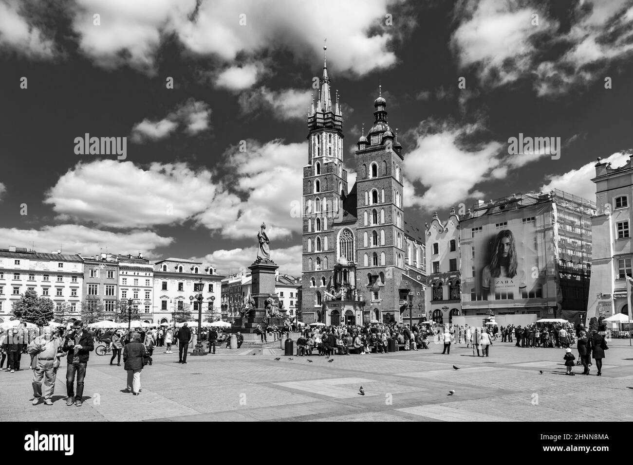 I turisti nella Piazza del mercato di Cracovia . La Piazza del mercato principale, una delle piazze medievali più grandi d'Europa, è stata costruita nel 1257 Foto Stock