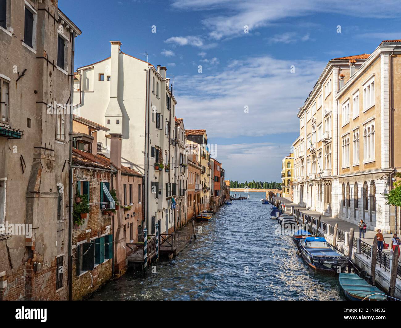 Canale veneziano con barche e vista sulla laguna. Foto Stock