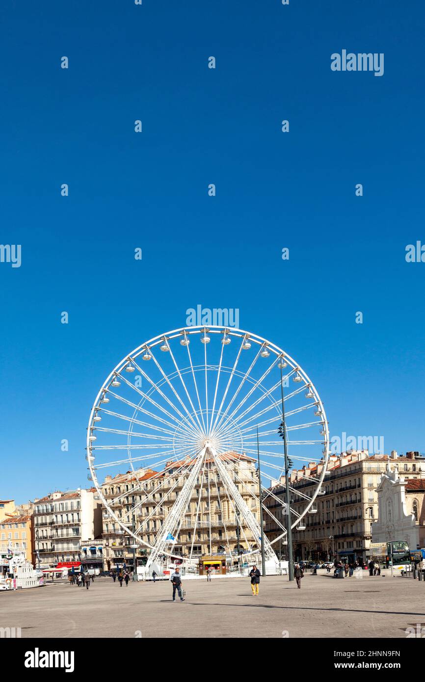 La gente gode di una grande ruota di ferro contro un cielo blu a Marsiglia Foto Stock