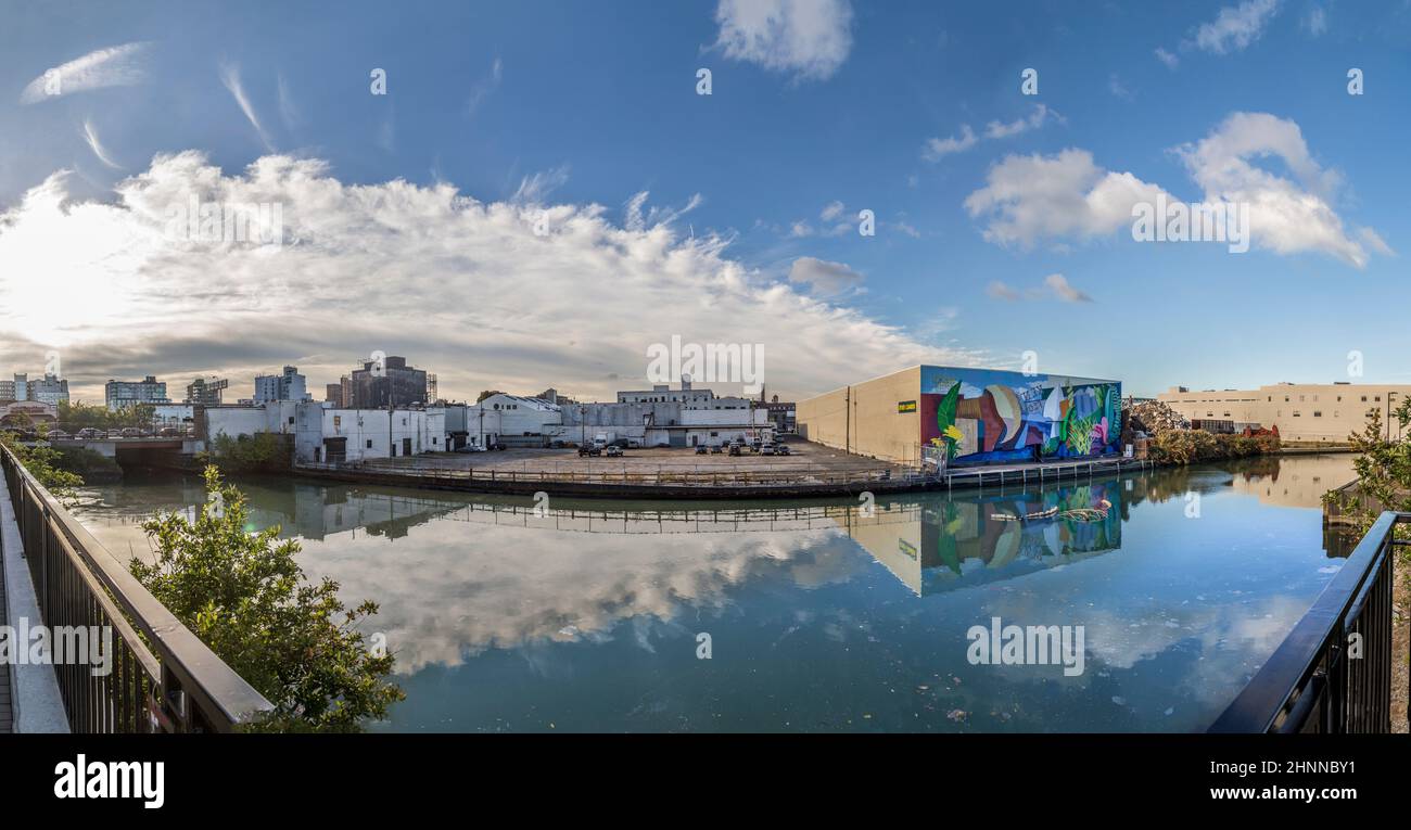 Vecchio edificio in mattoni presso un lago a New York, Brooklyn. I vecchi edifici industriali sono convertiti in negozi o appartamenti Foto Stock