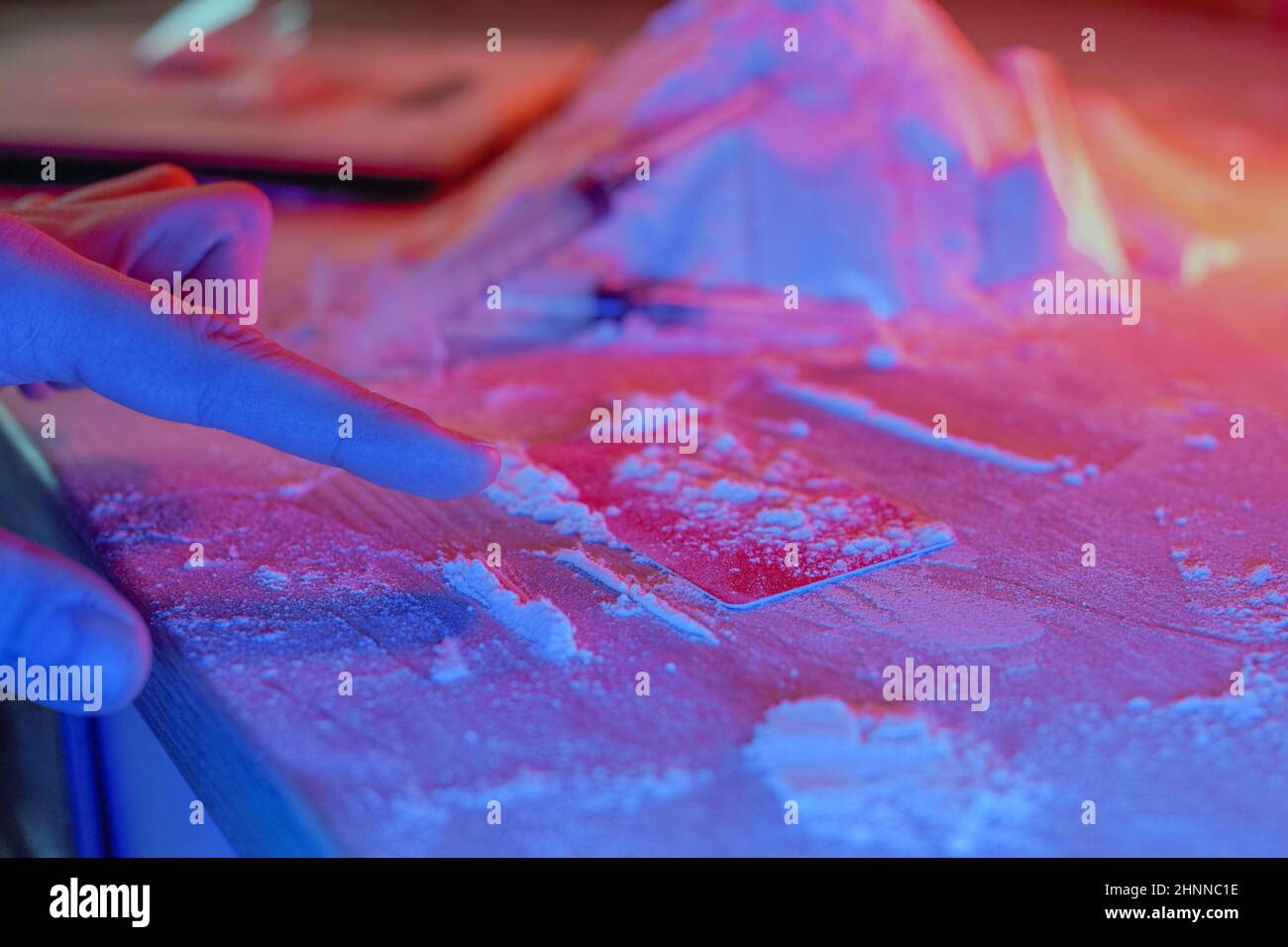 Droga, casa del commerciante della droga. Cocaina confezionata in bustine, scaglie: Compresse e siringhe al neon. Non valido, immissione. Foto Stock