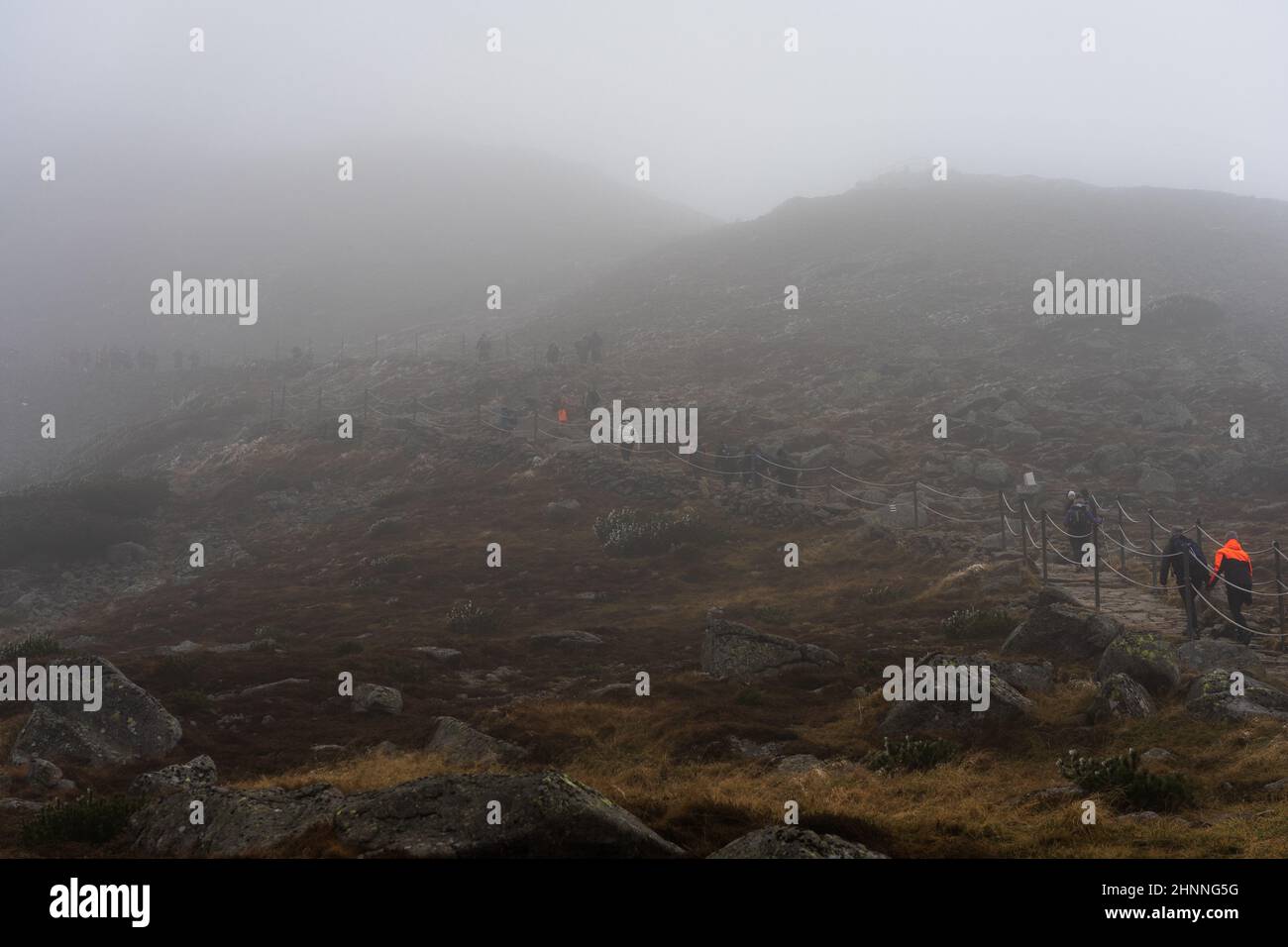 KARPACZ, POLONIA - 16 OTTOBRE 2021: I turisti salgono la popolare vetta della montagna polacca - Sniezka nelle montagne giganti in tempo nuvoloso. Foto Stock