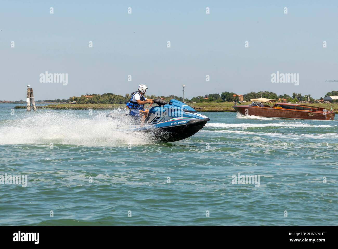 Polizia in una moto d'acqua che corre lungo la laguna a Venezia Foto Stock