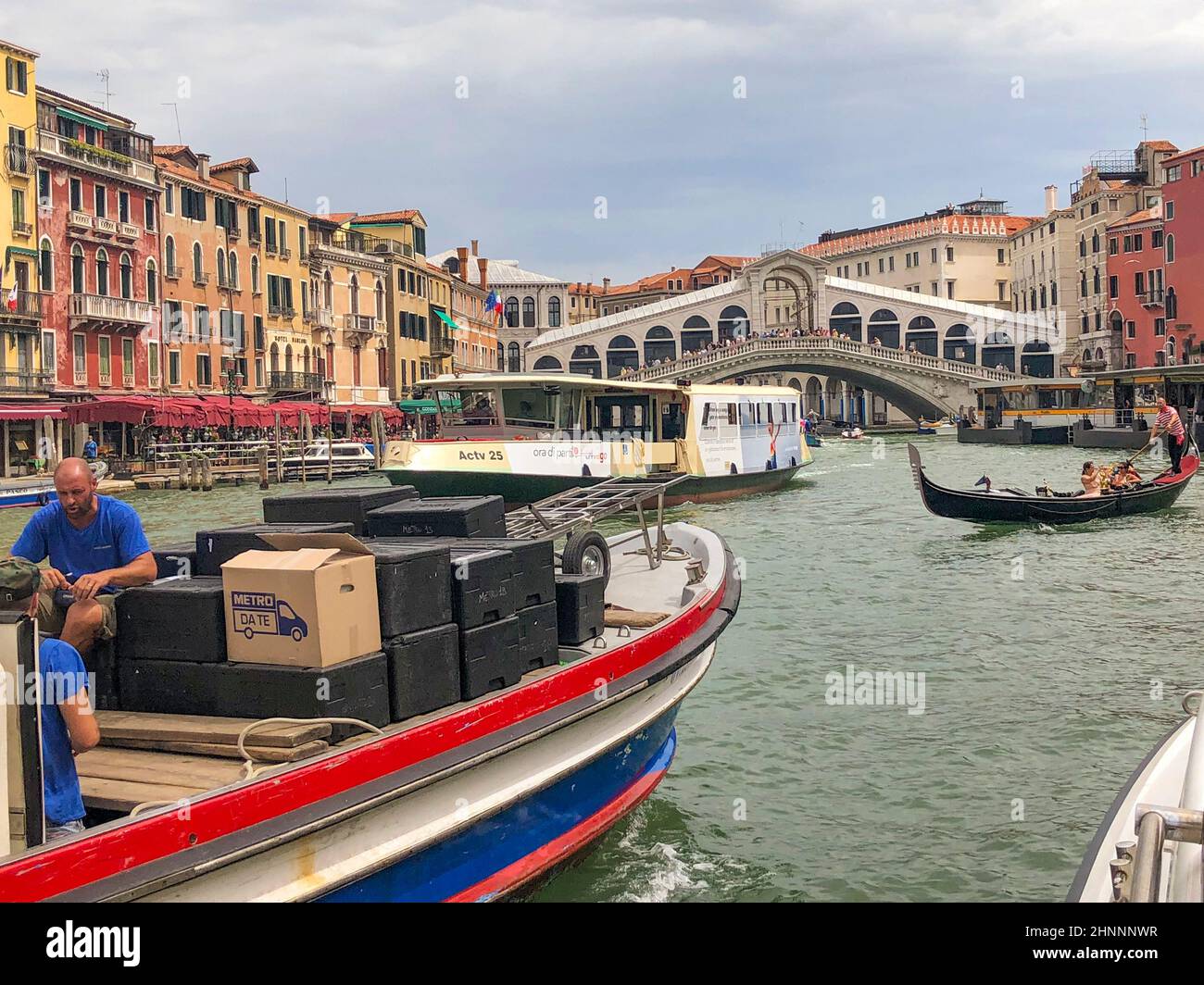 Nave da carico, vaporetto, trasporto pubblico e gondola sul Canal Grande al Ponte di rialto a Venezia Foto Stock