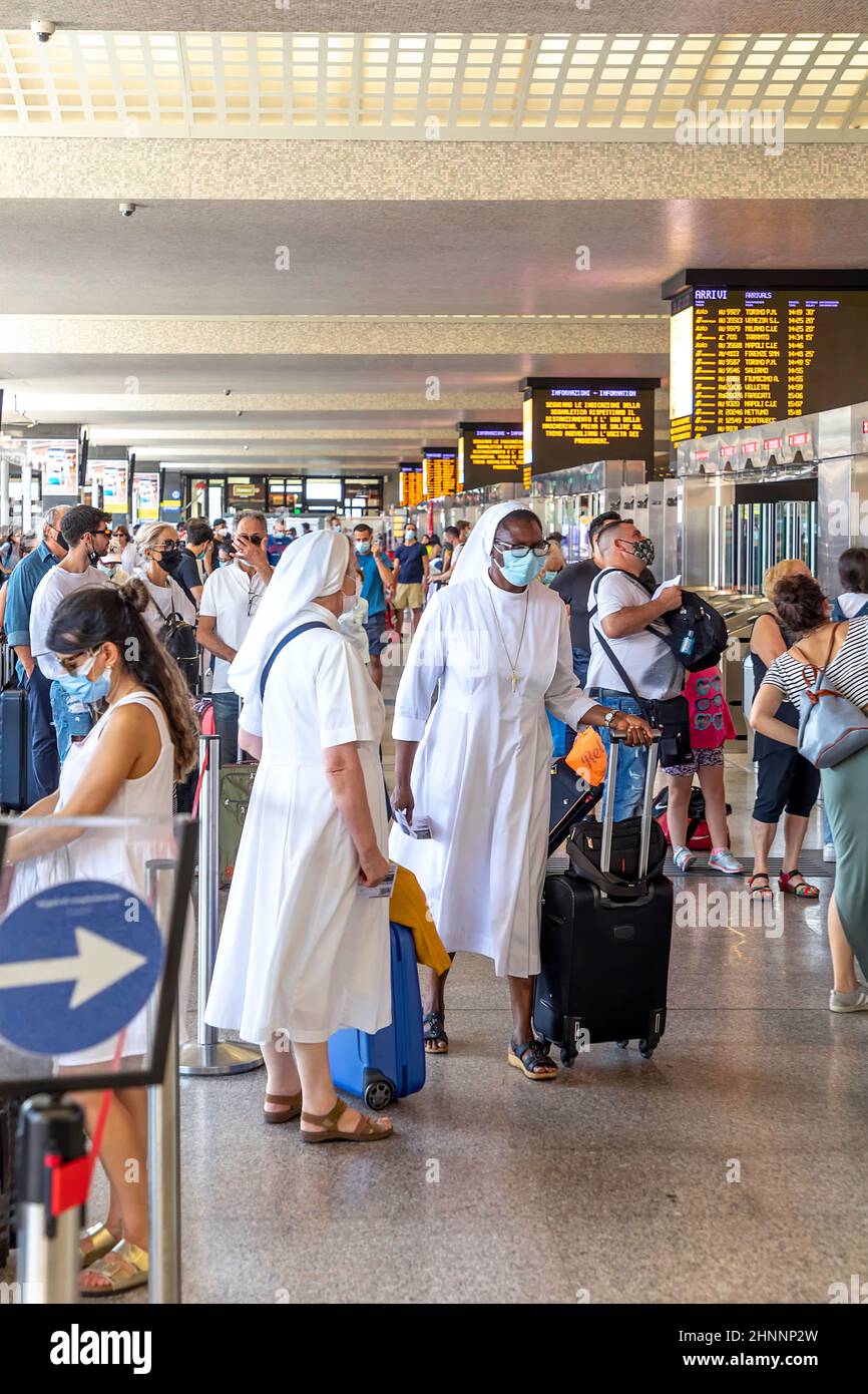 Le persone che si trovano nella stazione ferroviaria di Roma Termini sono sulla strada per il treno. Tutti indossano maschere per il viso per essere protetti da Corona. Foto Stock