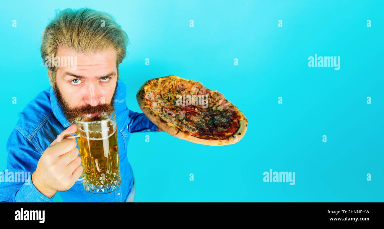 Uomo barbuto con tazza di birra e pizza al ristorante. Pranzo o cena. Fast food. Servizio di consegna. Foto Stock