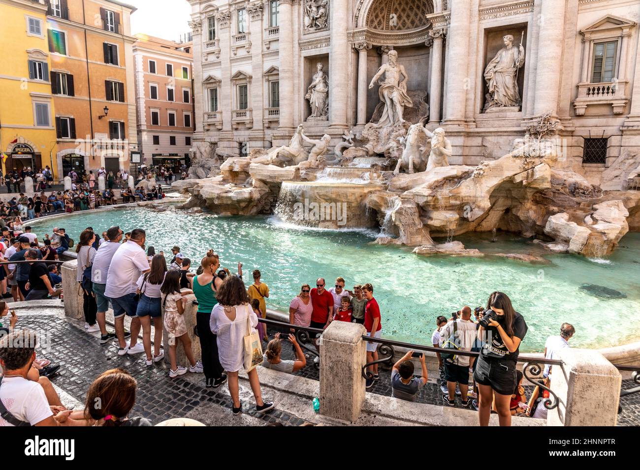 La gente visita la fontana di Trevi a Roma. Gettare le monete nella fontana dovrebbe dare fortuna alla gente. Foto Stock