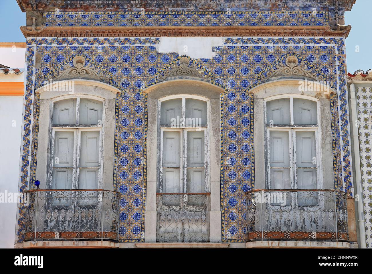 Facciata in piastrelle blu e giallo-vecchia casa cittadina abbandonata-balconi chiusi. Tavira-Portogallo-110 Foto Stock