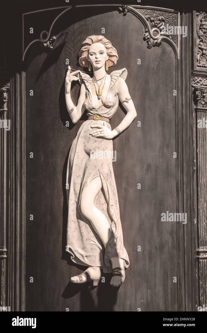 La scultura di una donna su una parete rotonda della casa. Foto Stock