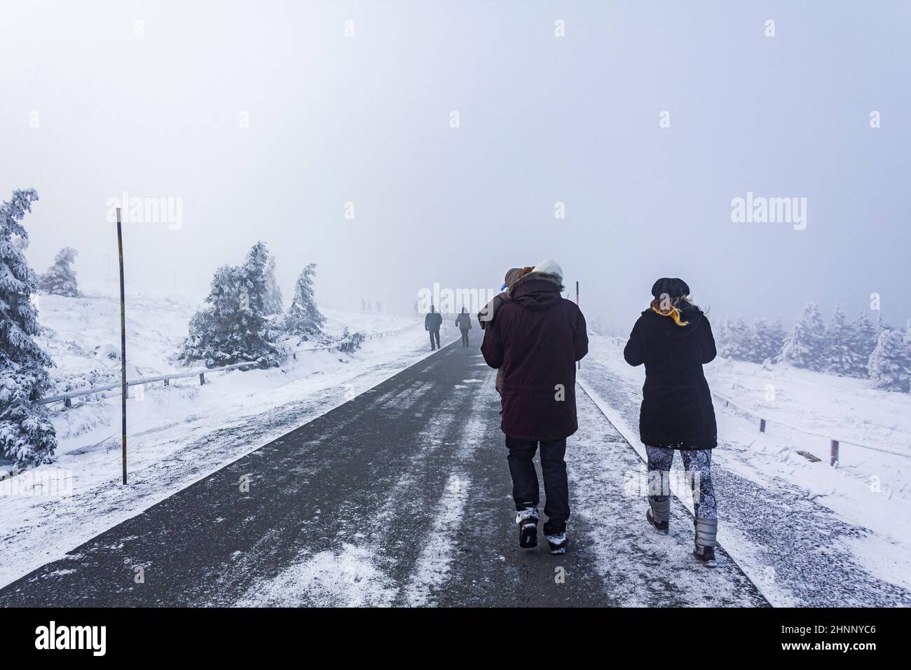 Escursionisti persone innevate nel paesaggio Brocken montagne Harz Germania. Foto Stock