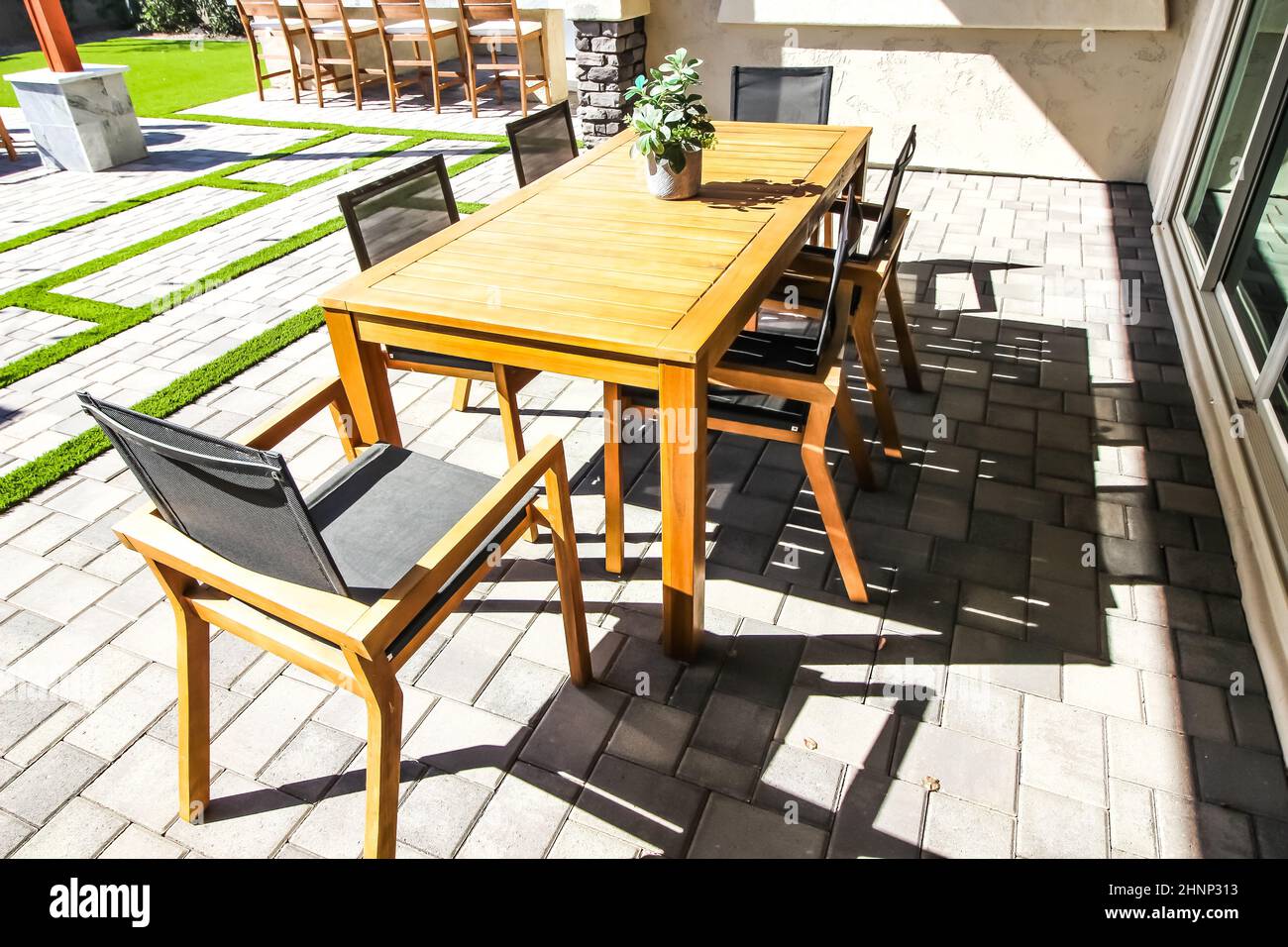 Tavolo in legno con sedie a sei braccia sul patio delle asfaltatrici posteriori Foto Stock