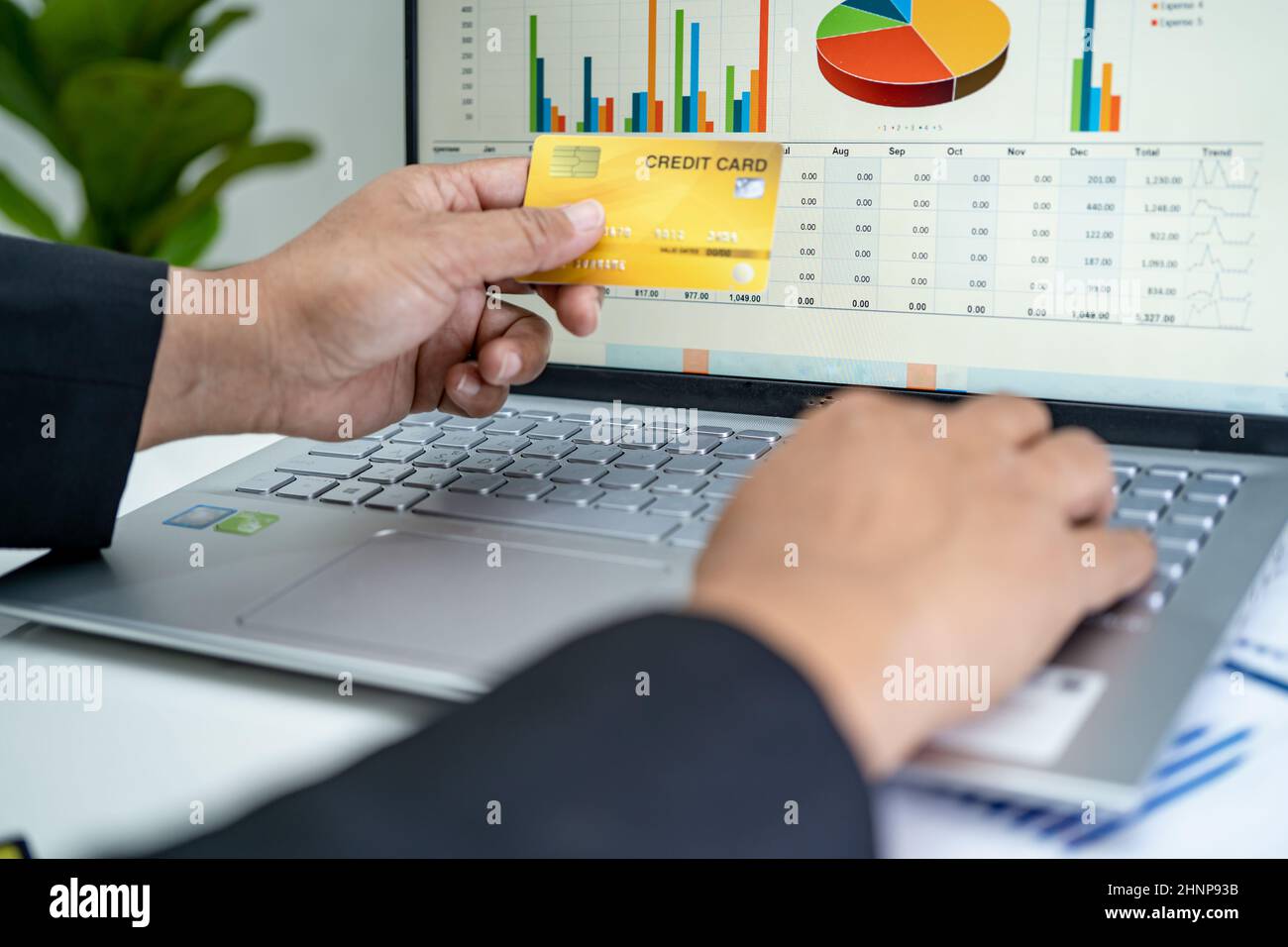 Ragioniere asiatico lavorare, calcolare e analizzare report di contabilità progetto con notebook e carta di credito in moderno ufficio, finanza e business concept. Foto Stock