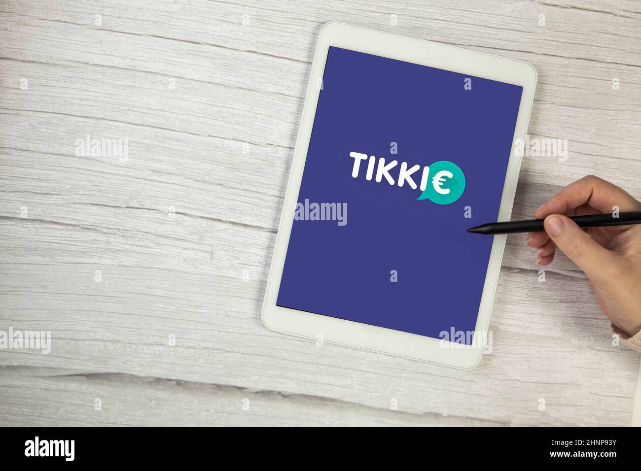 Paesi Bassi, dicembre 2021 Mobile app Tikkie. Tikkie è un'applicazione popolare olandese con cui è possibile recuperare denaro se si è avanzato. Trasferire denaro su tablet digitale su spazio di copia in legno Foto Stock