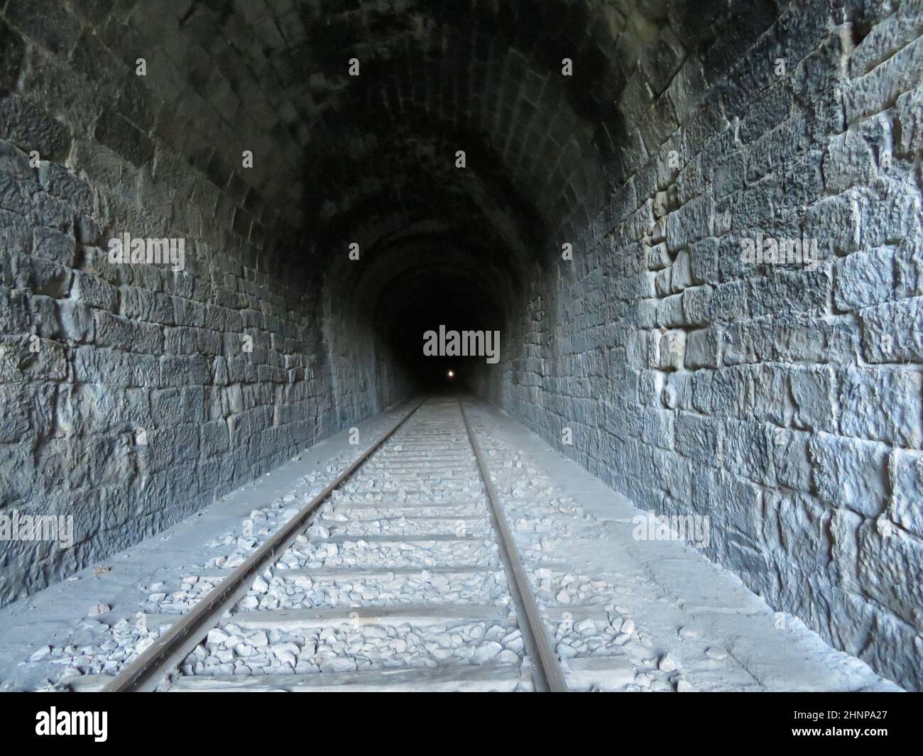 la strada in ferro collega il faro ferroviario in metallo alla fine del trasporto ferroviario in galleria Foto Stock