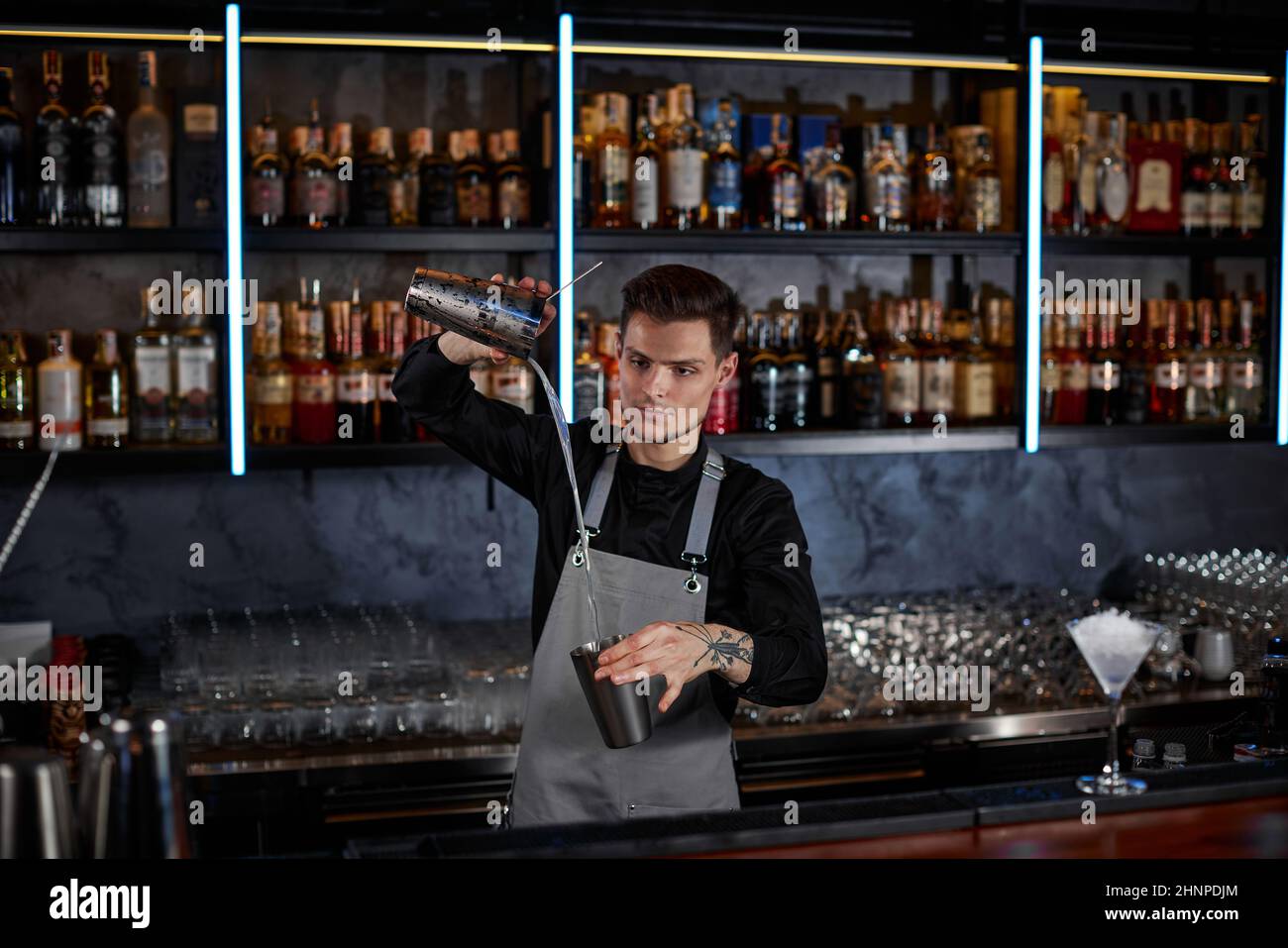 il barman sta facendo il cocktail con lo shaker dell'acciaio Foto Stock