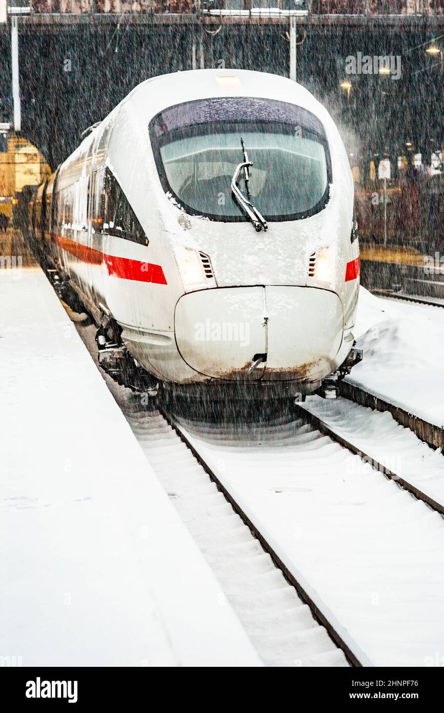Nevicate alla stazione ferroviaria di Wiesbaden, Germania con treno ad alta velocità sulla neve Foto Stock