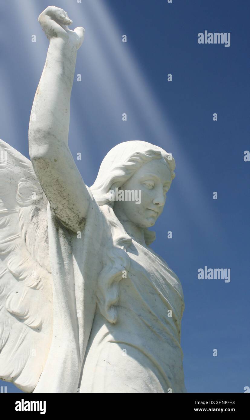 Statua storica dell'Angelo con cielo blu e fasci di luce Foto Stock