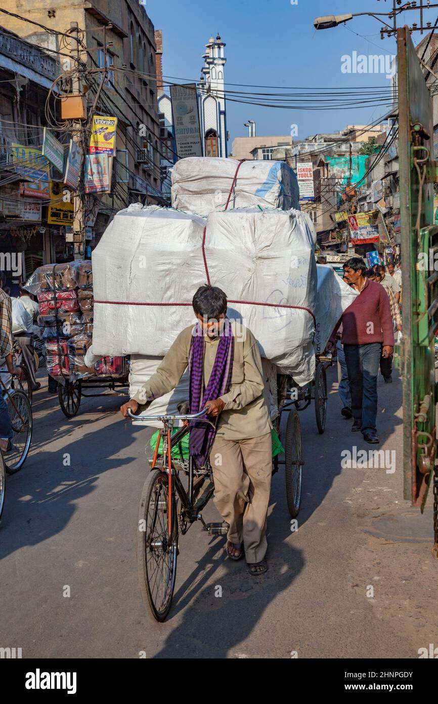 L'uomo trasporta il carico enorme con la sua bicicletta nella vecchia Delhi, Bazaar di Chawri. Foto Stock