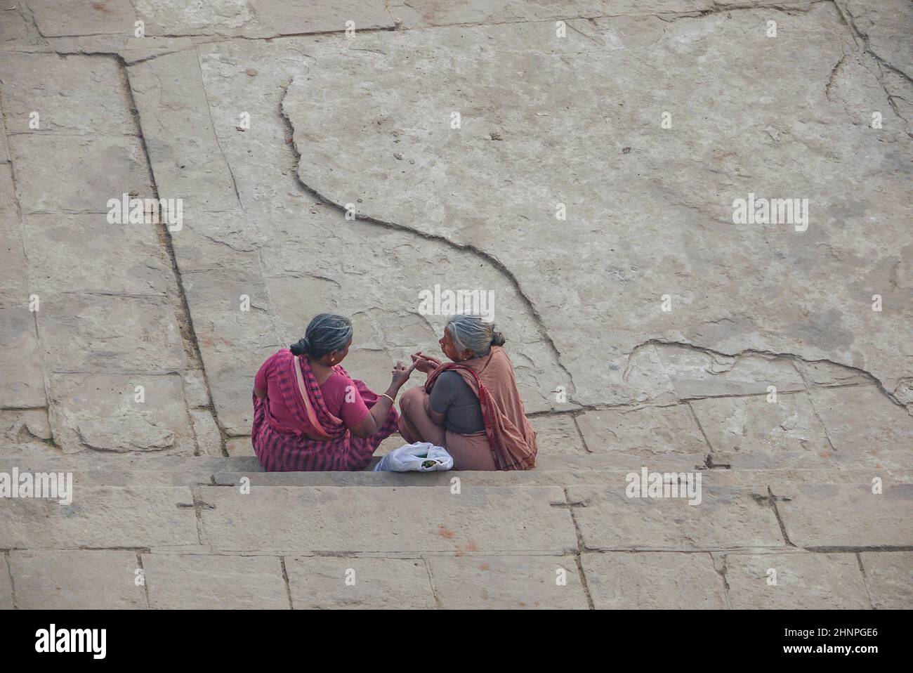 due donne indiane povere e anziane si siedono a terra e discutono. Appartengono alla casta degli Shudra, i lavoratori Foto Stock