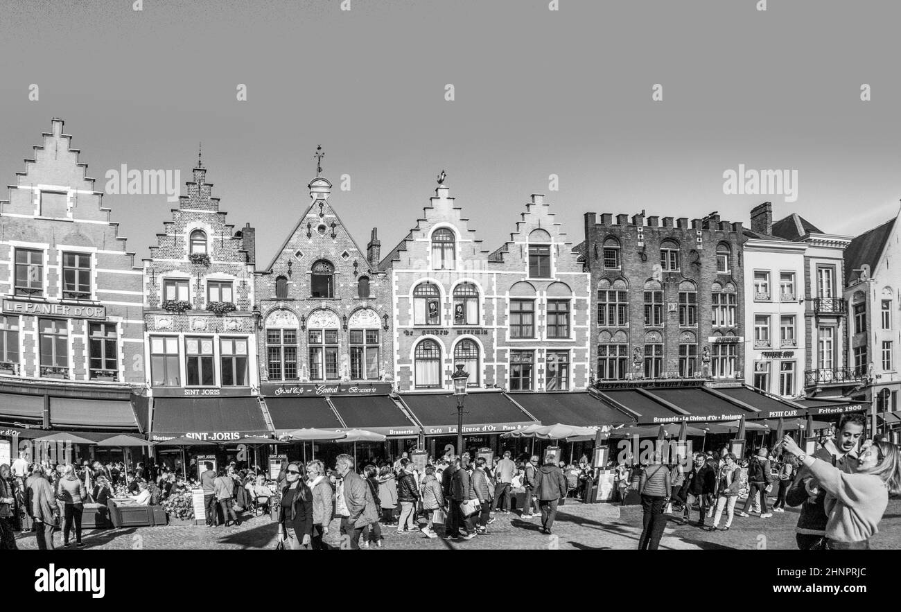 I turisti godono di una splendida giornata di sole e scattano foto nella Piazza del mercato (Markt) di Bruges. Foto Stock