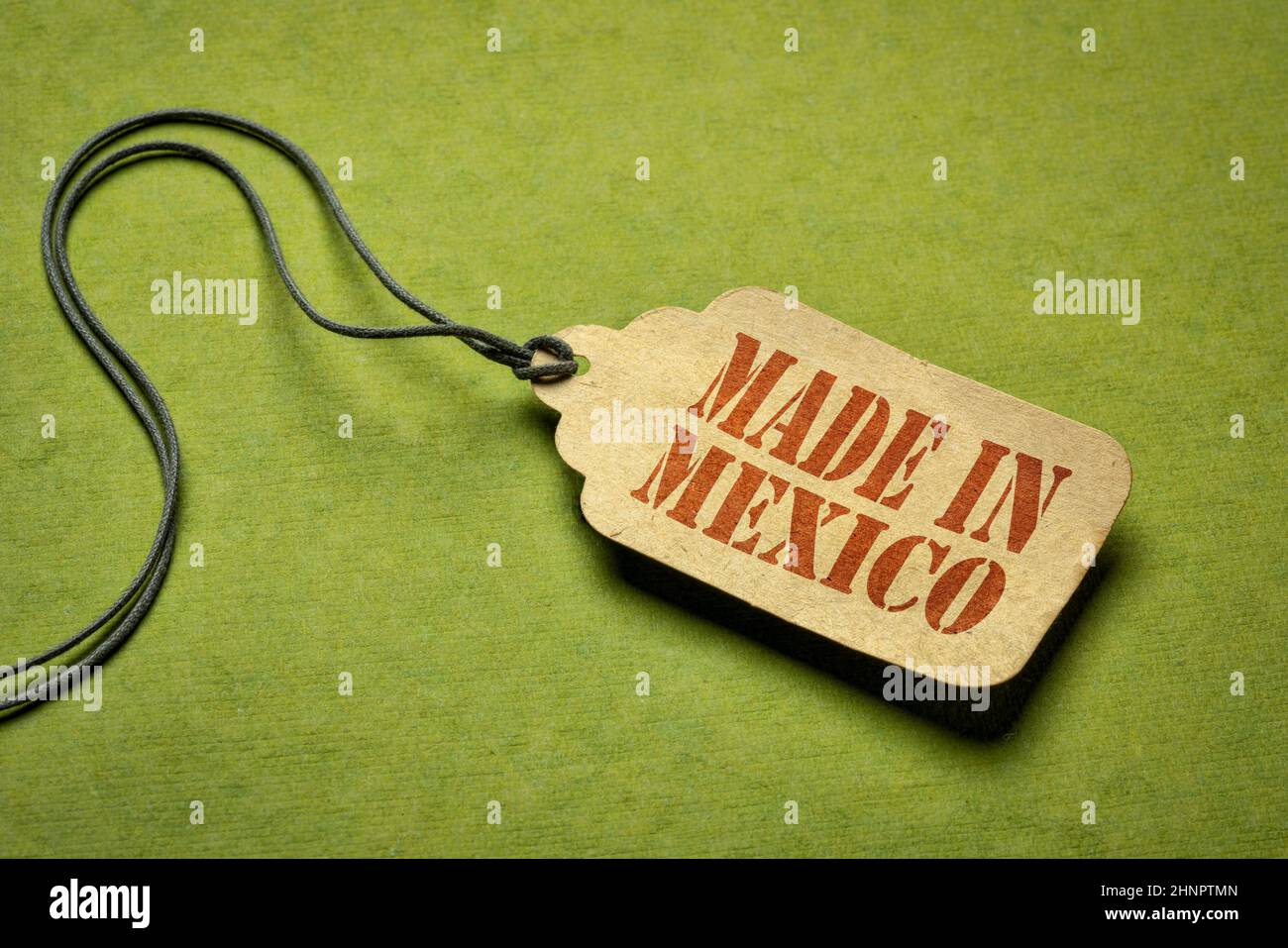 Made in Mexico sign - testo stencil rosso su un'etichetta prezzo contro carta verde testurizzata Foto Stock
