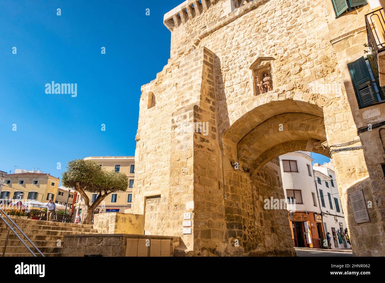 Primo piano della storica porta in pietra della città di Mahon Menorca contro un cielo blu illuminato dal sole Foto Stock