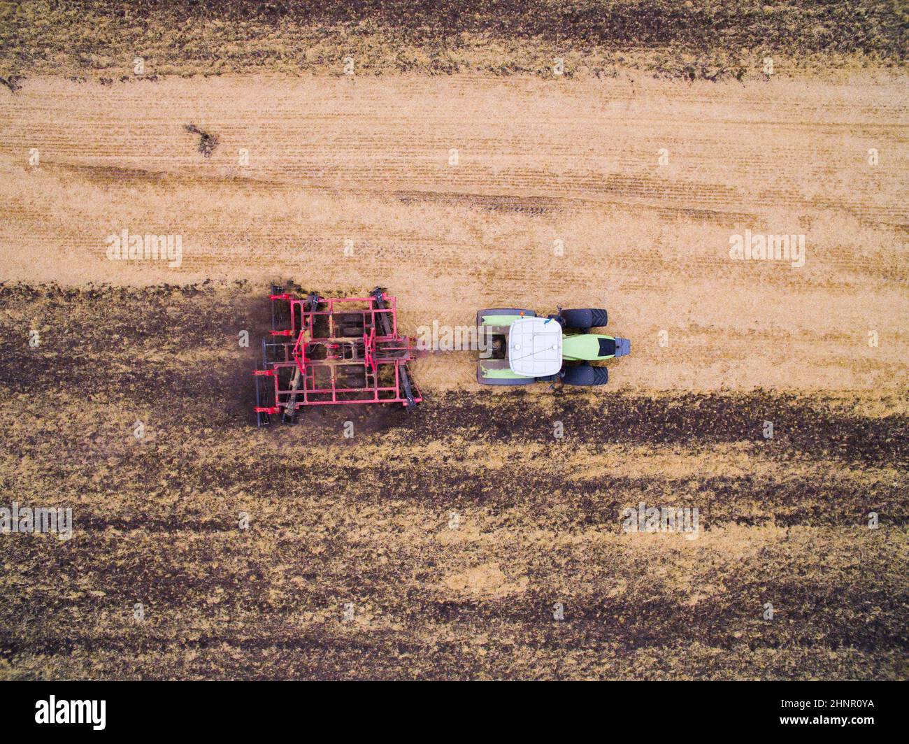 Raccolta sul campo. Vista aerea. Coltivazione del terreno con un trattore Foto Stock