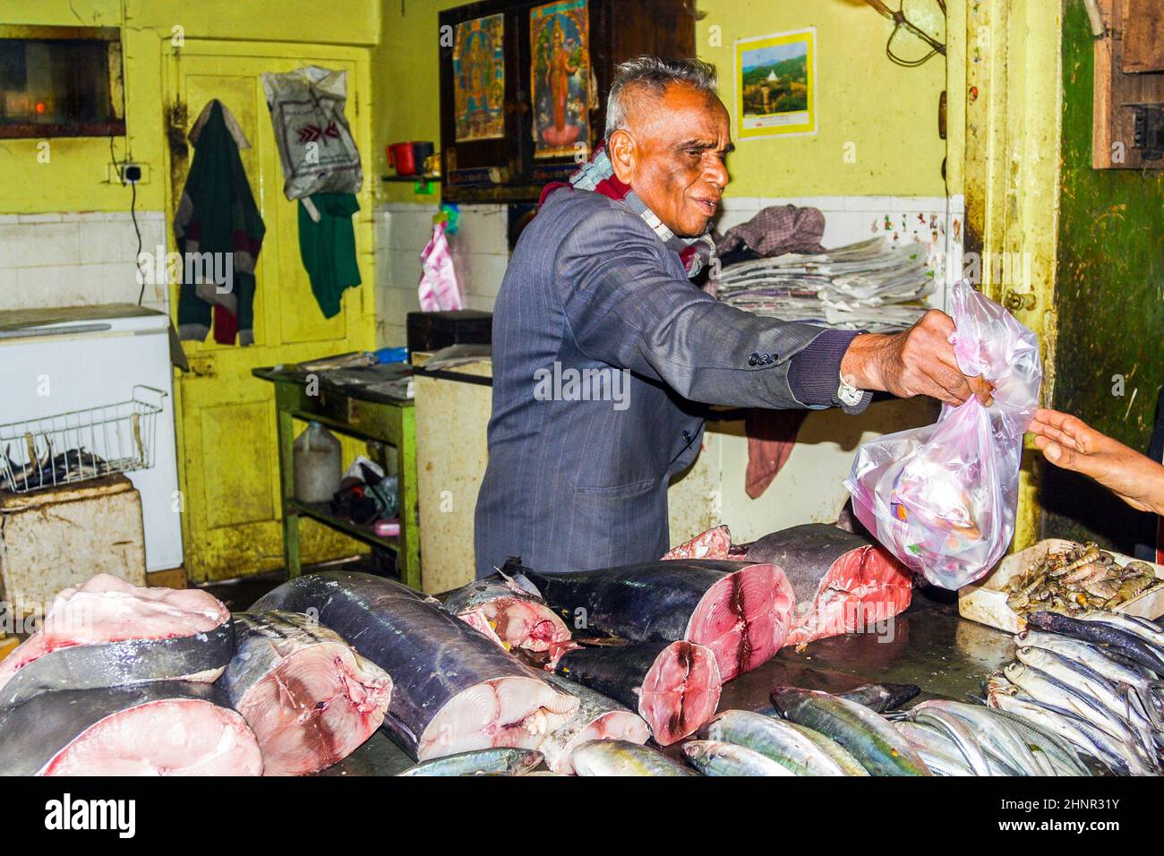 l'uomo vende pesce fresco nel suo negozio Foto Stock