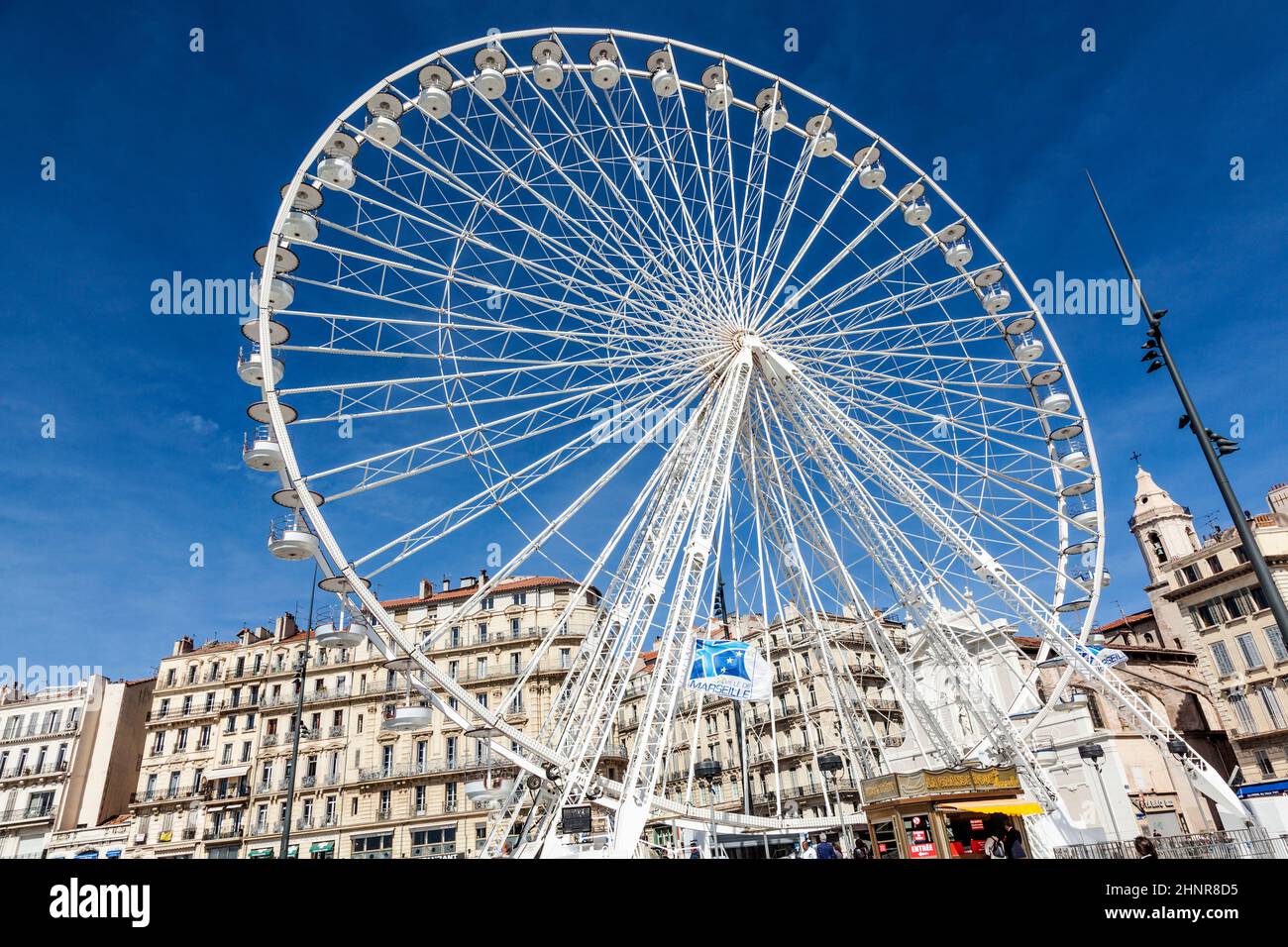 La gente gode di una grande ruota di ferro contro un cielo blu a Marsiglia Foto Stock