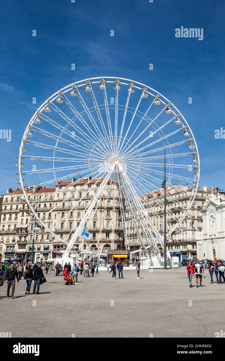 La gente gode di una grande ruota di ferro contro un cielo blu a Marsiglia Foto Stock