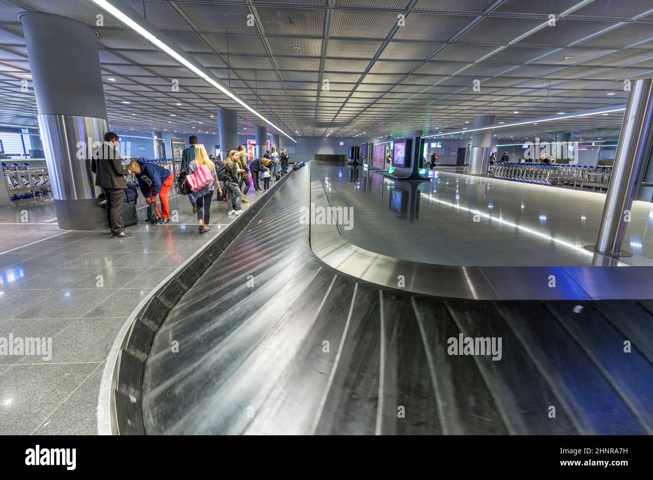 La gente aspetta i bagagli presso la cintura bagagli dell'aeroporto di Francoforte Foto Stock