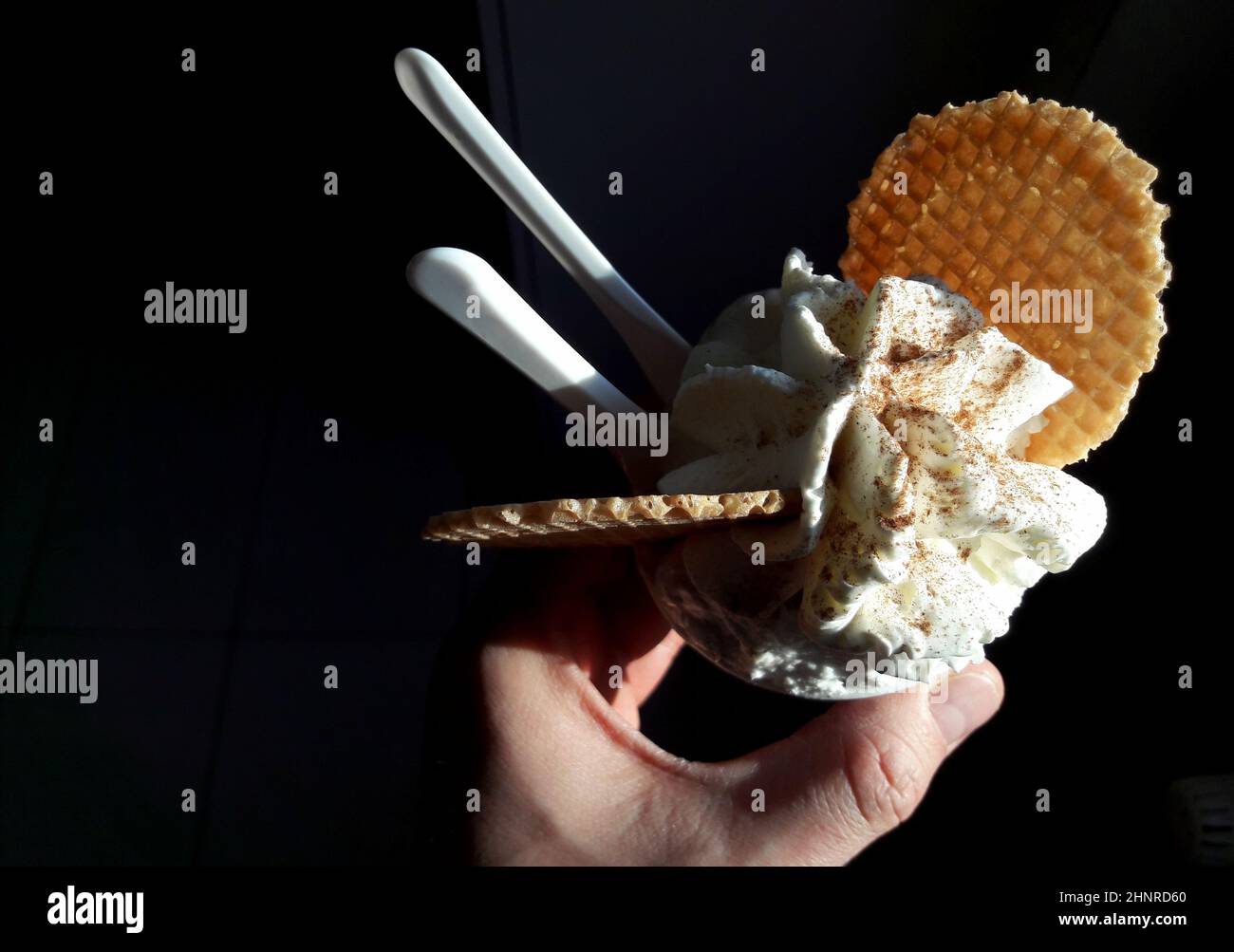 Primo piano di un gelato in mano isolato su sfondo nero Foto Stock