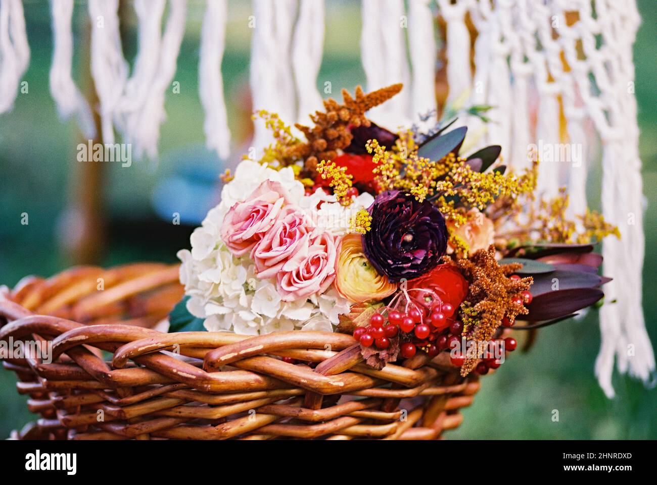 Bouquet nuziale a tema autunnale in un cestino di fronte a Macrame Foto Stock