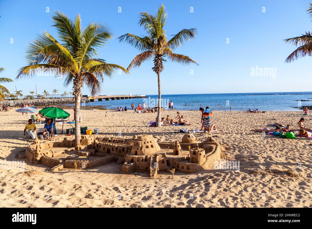 La gente gode la spiaggia di Arrecife e costruire castelli con sabbia sotto le palme Foto Stock