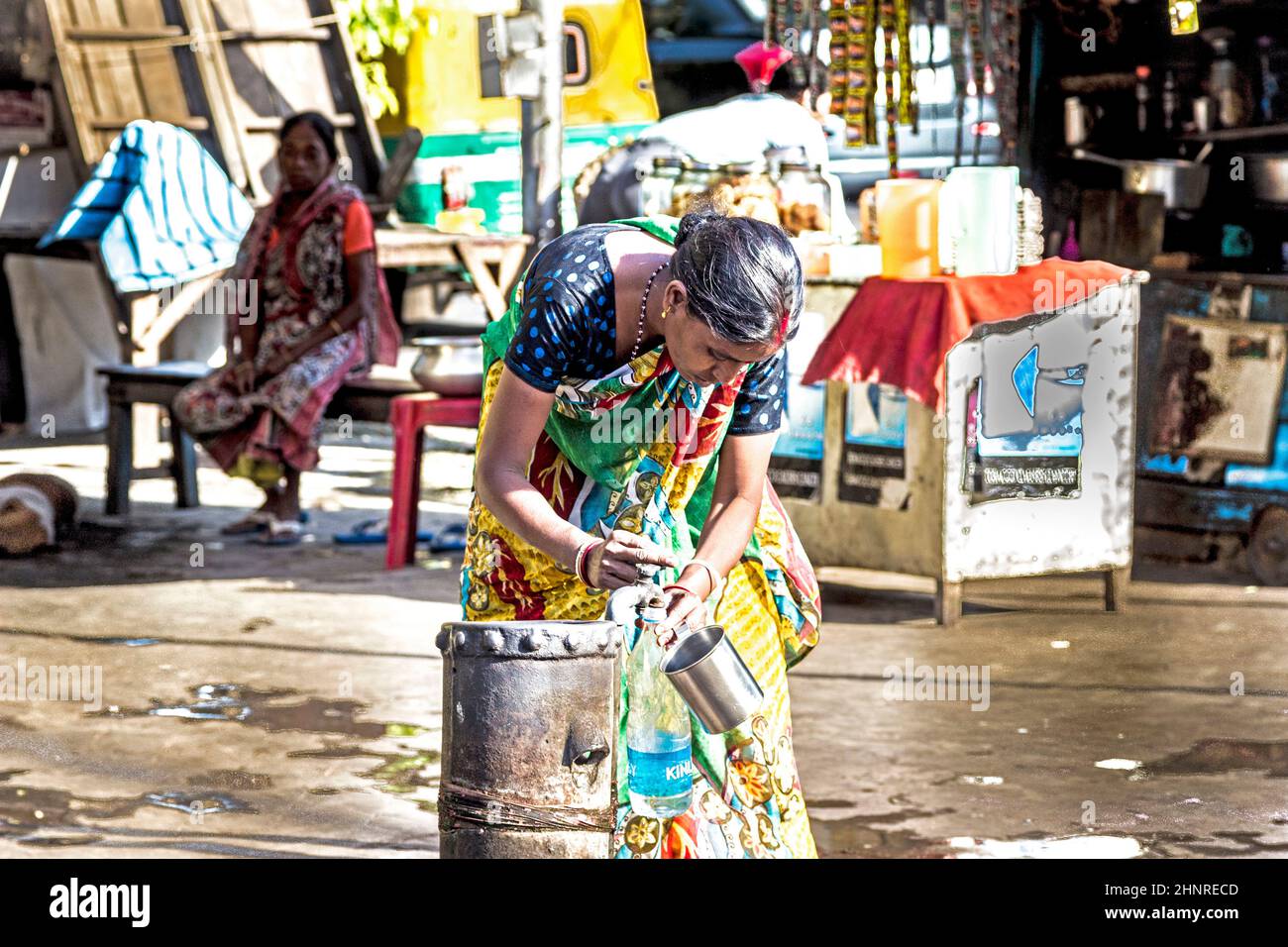 La donna riceve acqua pulita da un idrante nella parte vecchia di Calcutta Foto Stock
