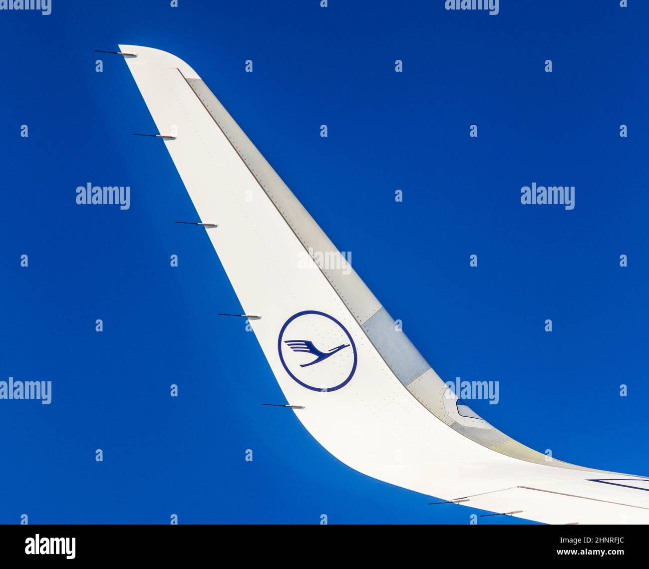 Ala sinistra di velivolo Lufthansa in cielo blu Foto Stock