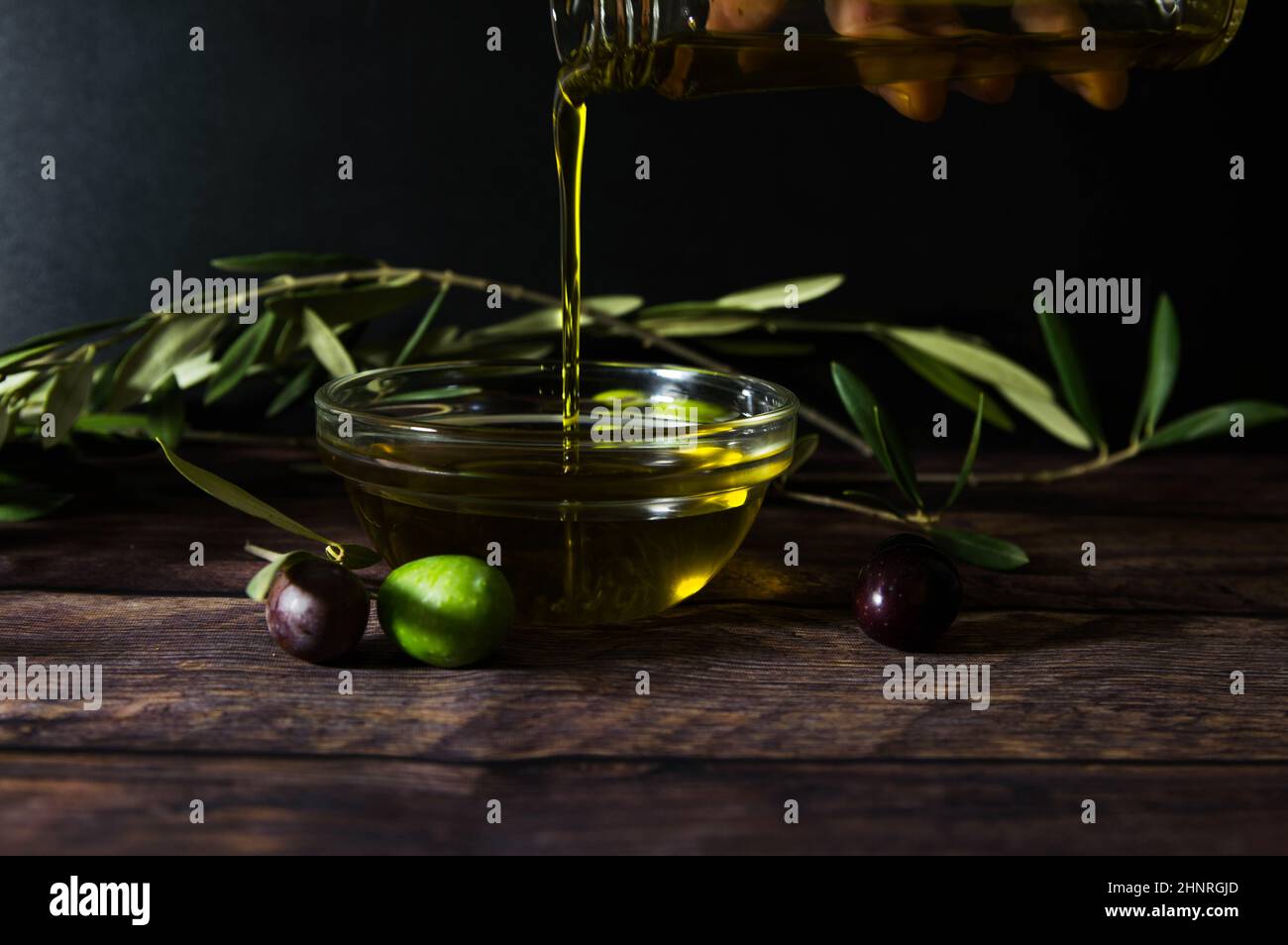 Olio d'oliva su tavola di legno Foto Stock