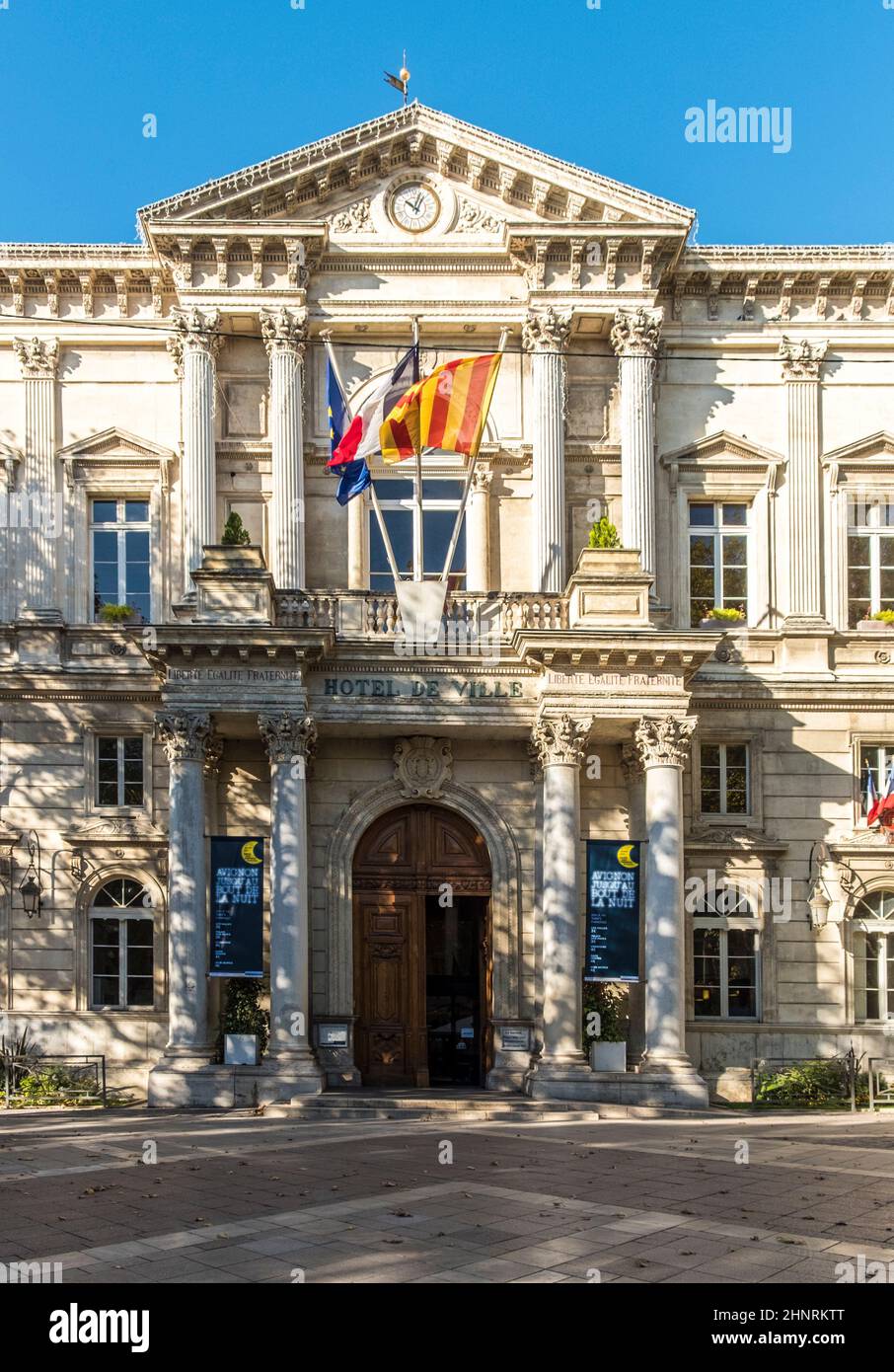Municipio nella città francese di Avignone con bandiere e orologio Foto Stock Municipio nella città francese di Avignone con bandiere e orologio Foto Stock