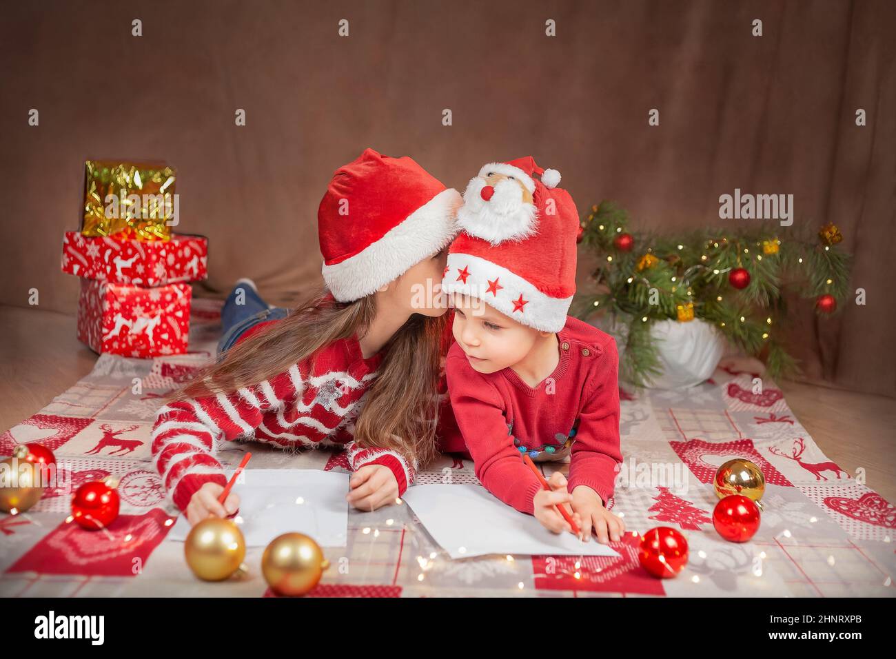 Felice ragazzo e ragazza scrivere una lettera a Babbo Natale. Foto Stock