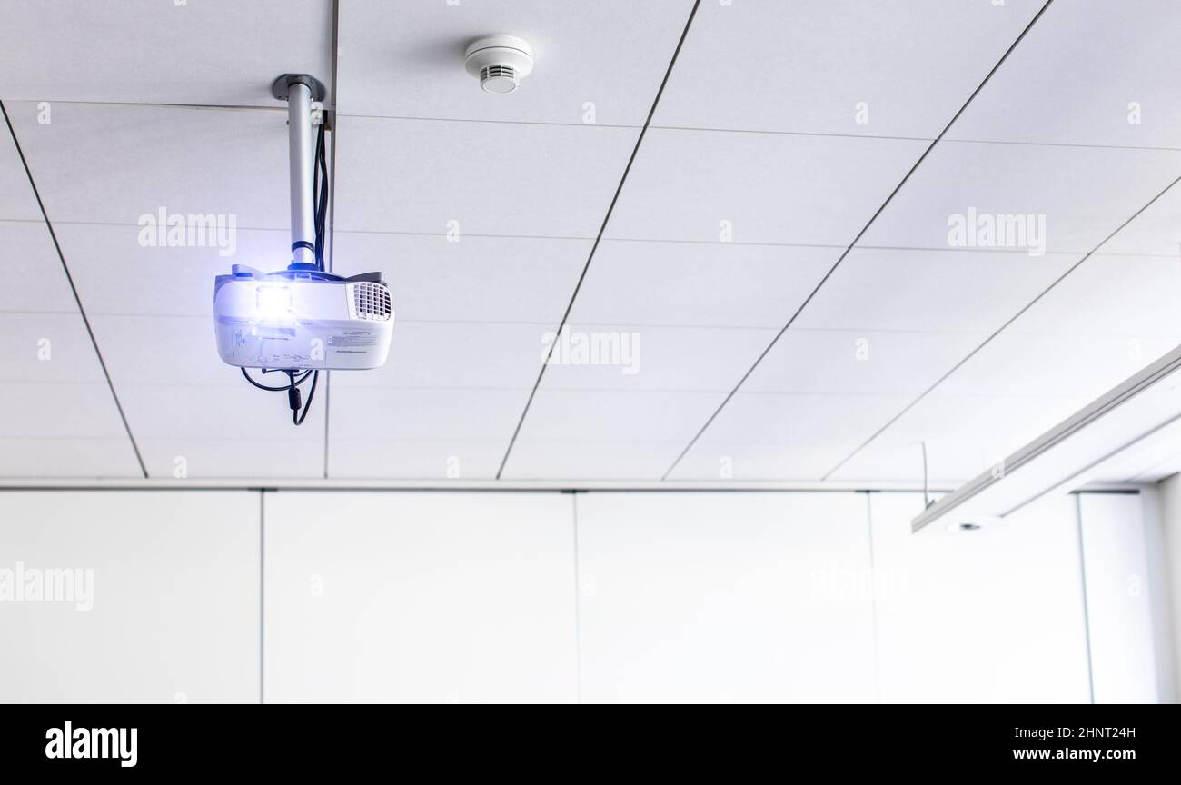 Un proiettore a soffitto bianco in una sala conferenze/classe moderna (immagine a colori) Foto Stock
