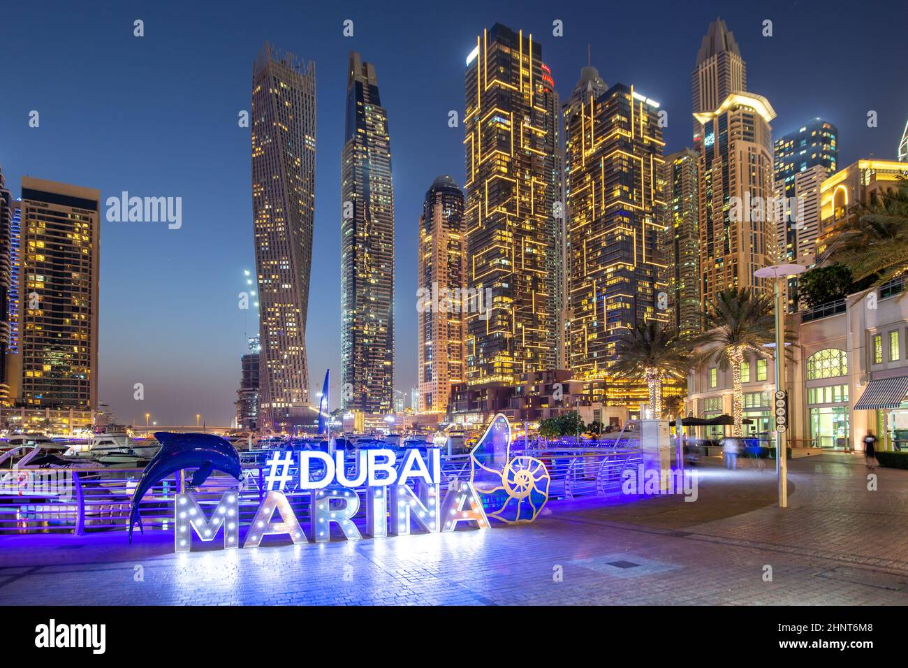 Il logo Dubai Marina e l'architettura dello skyline del porto arricchirono il viaggio di lusso di notte negli Emirati Arabi Uniti Foto Stock