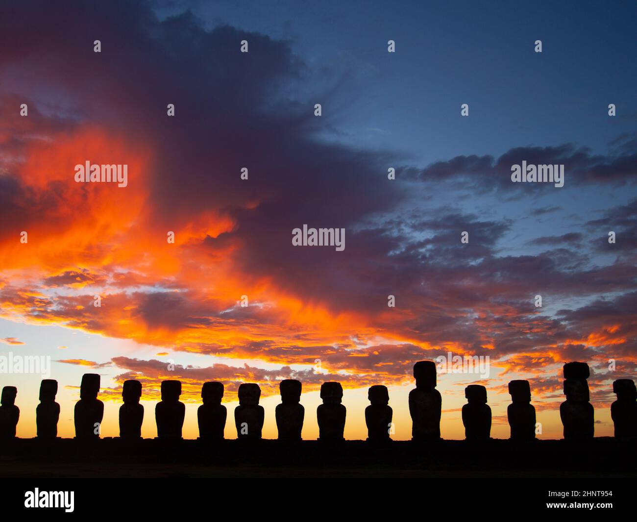 Drammatico e colorato sorgere del sole sulle sculture di pietra di Moai a AHU Tongariki, isola di Pasqua, Cile. Foto Stock