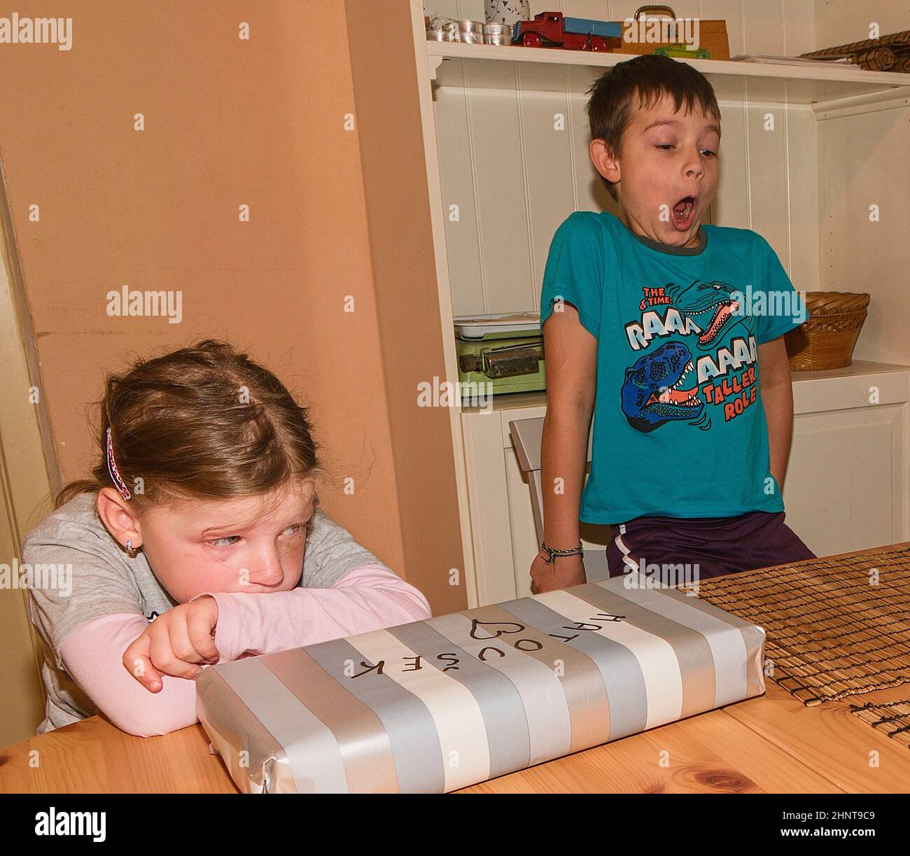 Ragazzo festeggia il nono compleanno. Fratello e sua sorella delusa. Foto Stock