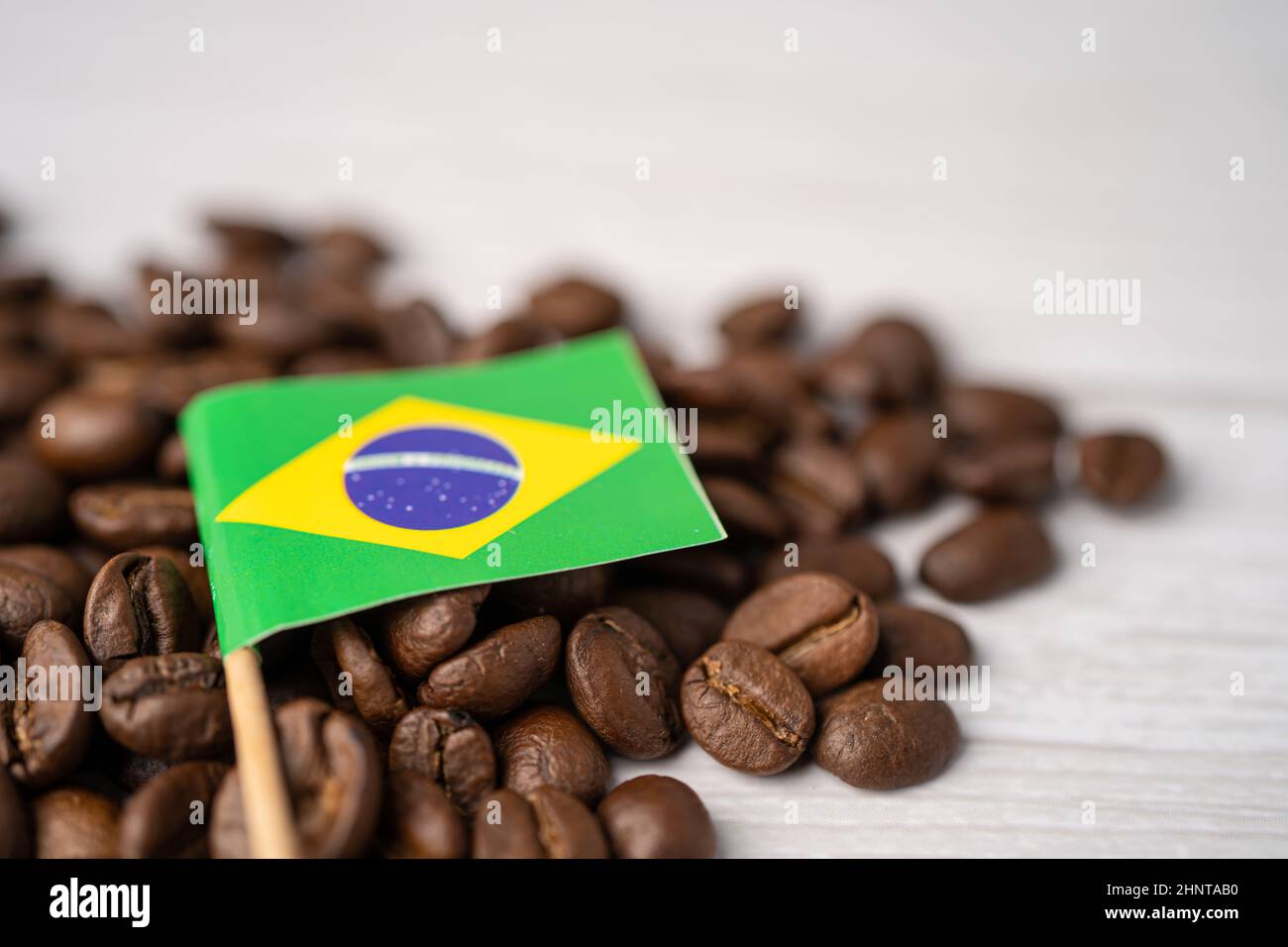 Bandiera del Brasile sui chicchi di caffè; concetto di cibo per bevande per l'importazione. Foto Stock